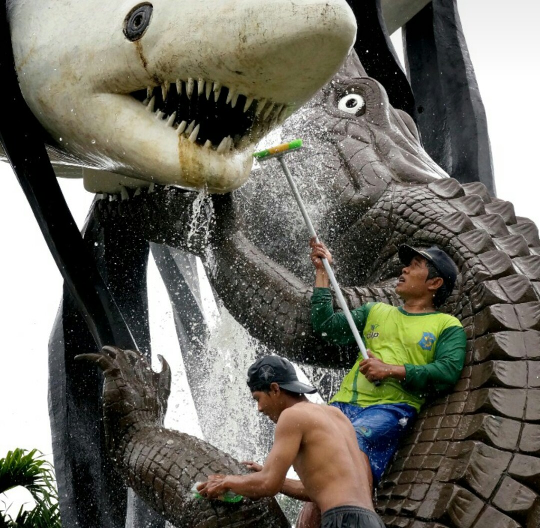 Petugas membersihkan Monumen Suro Boyo menjadi ikon Kota Surabaya. 