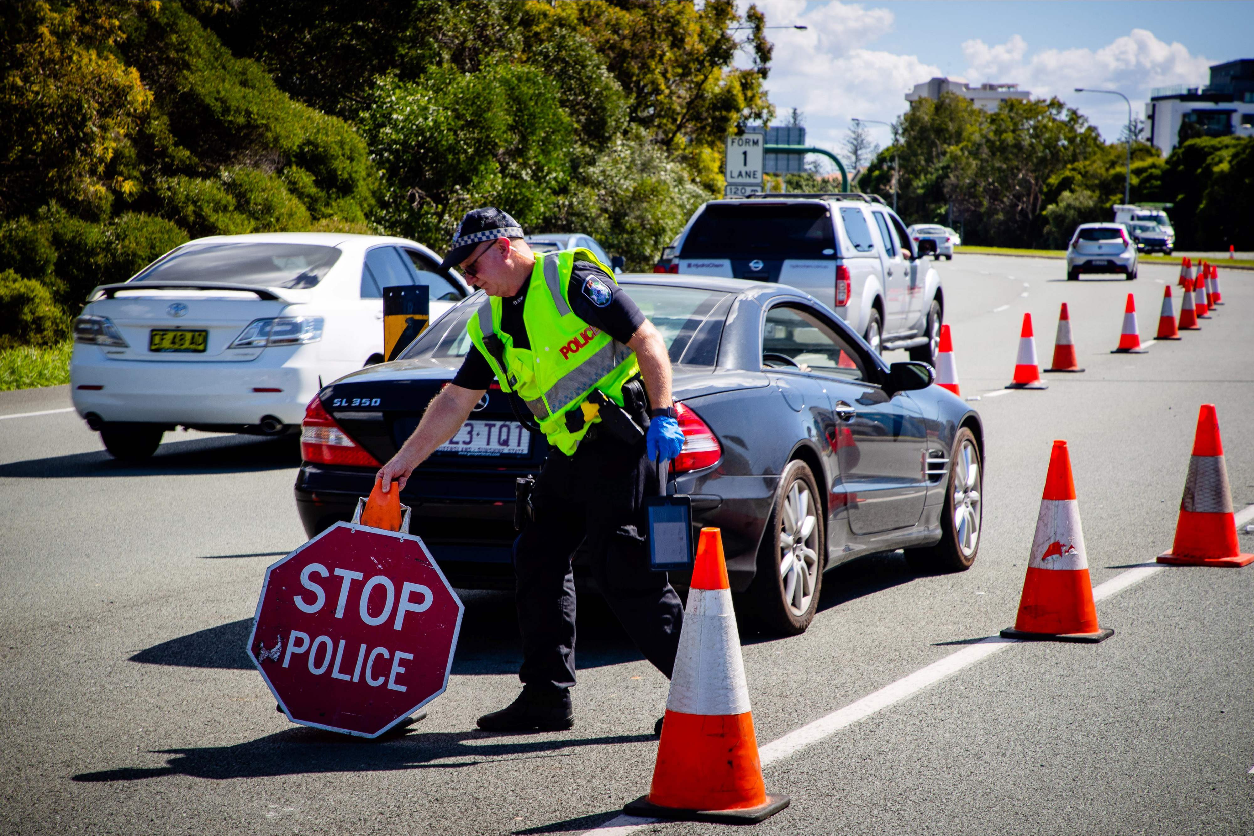 Polisi memeriksa mobil yang akan masuk Negara Bagian Queensland dari New South Wales.