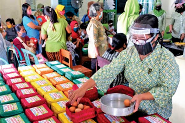 Anggota Ikatan Istri Dokter Indonesia (IIDI) Solo menyiapkan bingkisan berisi telur saat sosialisasi kepada warga di Cinderejo, Solo