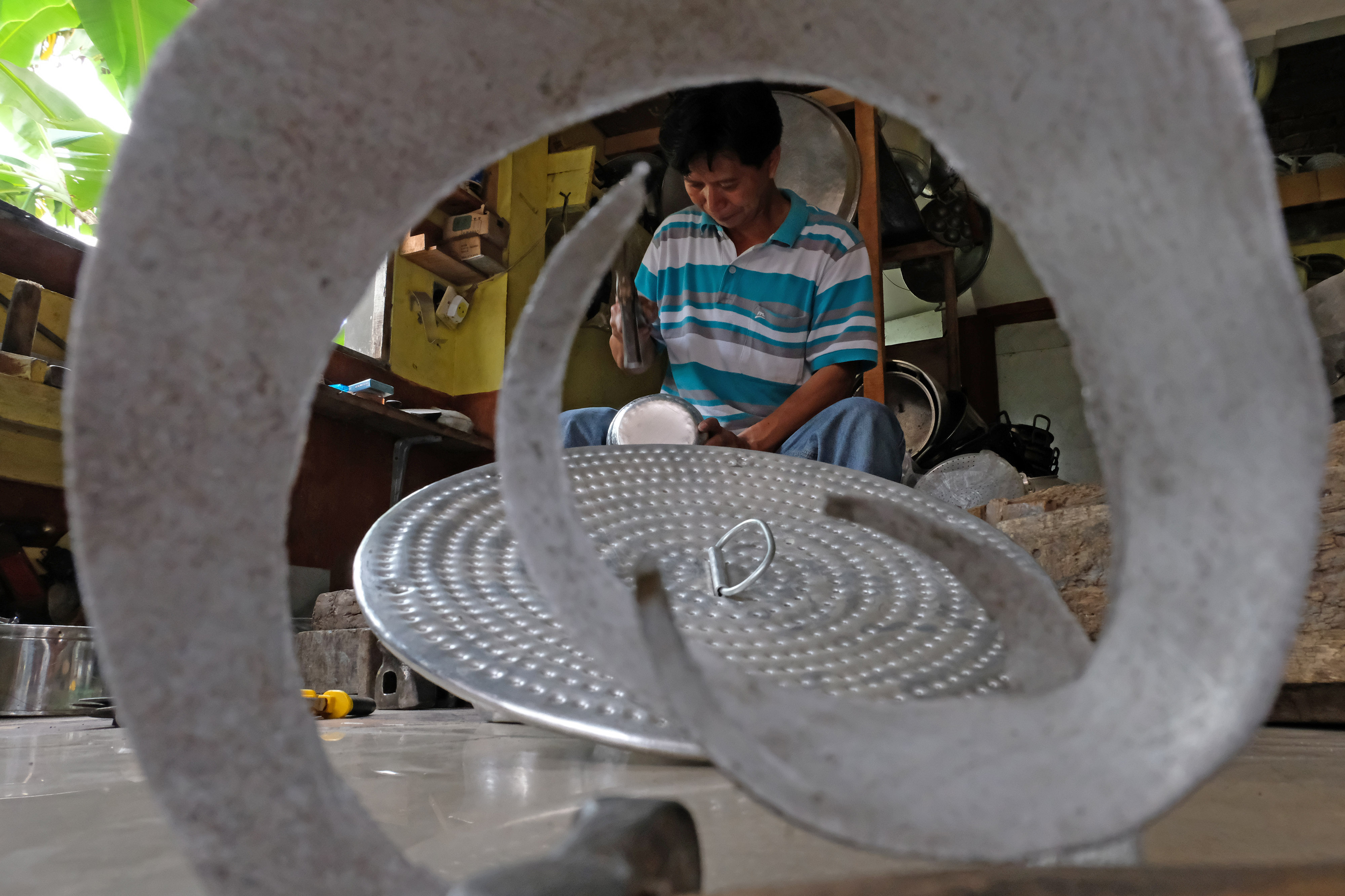 Seorang perajin membuat kerajinan dari bahan alumunium. Saat ini ekspor alumunium dari Indonesia mencapai 2.000 ton. 