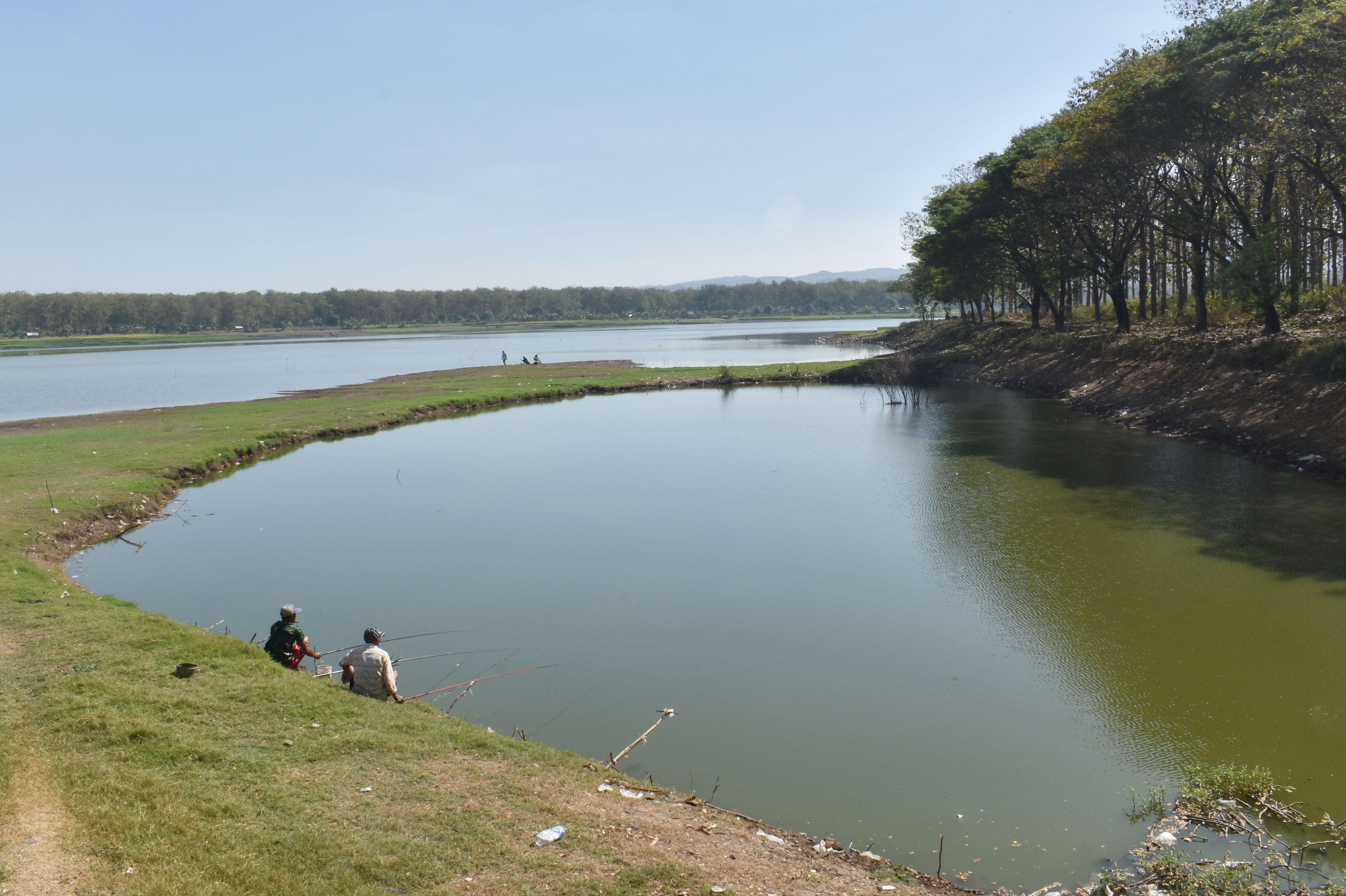 Warga memancing ikan di Waduk Saradan yang debit airnya mulai menyusut di Kabupaten Madiun, Jawa Timur, Sabtu (25/7).