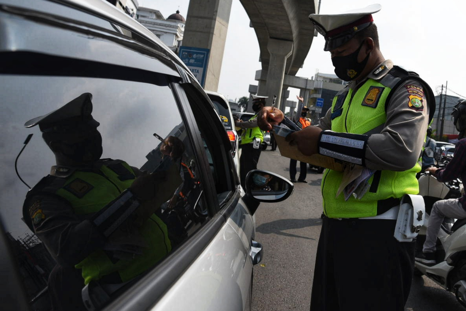Ilustrasi--polisi menilang pengemudi kendaraan roda empat yang melanggar aturan ganjil genap di Fatmawati.