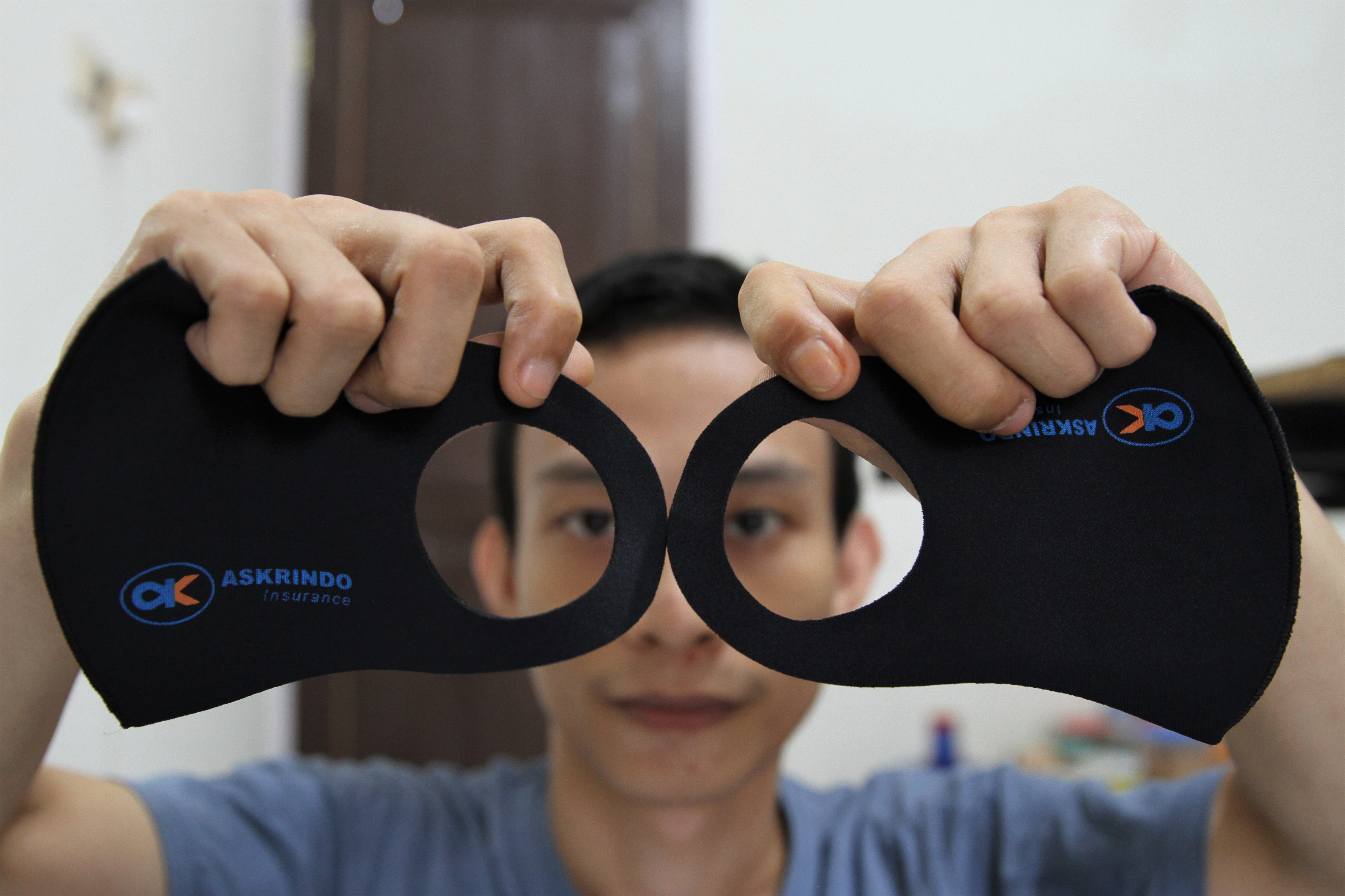 Perajin menunjukan hasil sablon di masker model scuba