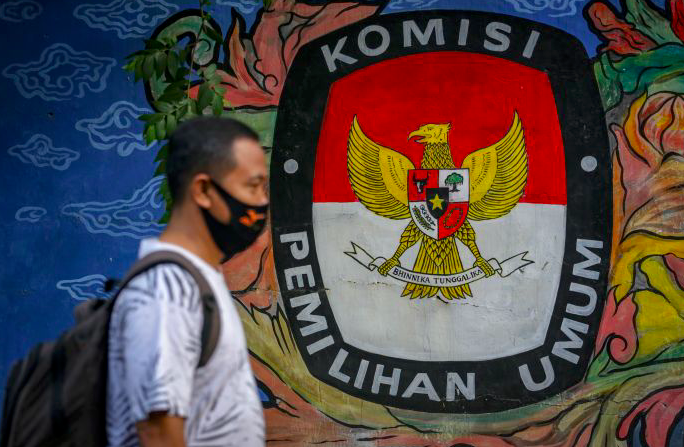 Warga melintasi mural bertema pemilihan umum di Kota Tangerang, Banten, Kamis (7/5/2020).  