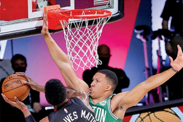 Pemain Boston Celtics Grant Williams (kiri) mencoba memblok bola yang dibawa pemain Miami Heat Bam Adebayo