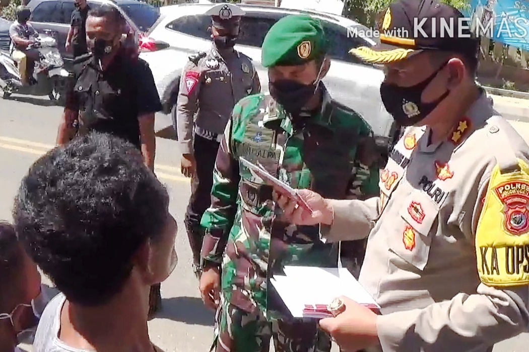 Kapolres Bambang Hari Wibowo bersama Dandim Manggarai Letkol Kav Ivan Alfa membagikan masker sumbangan presiden Jokowi di Labuan Bajo.