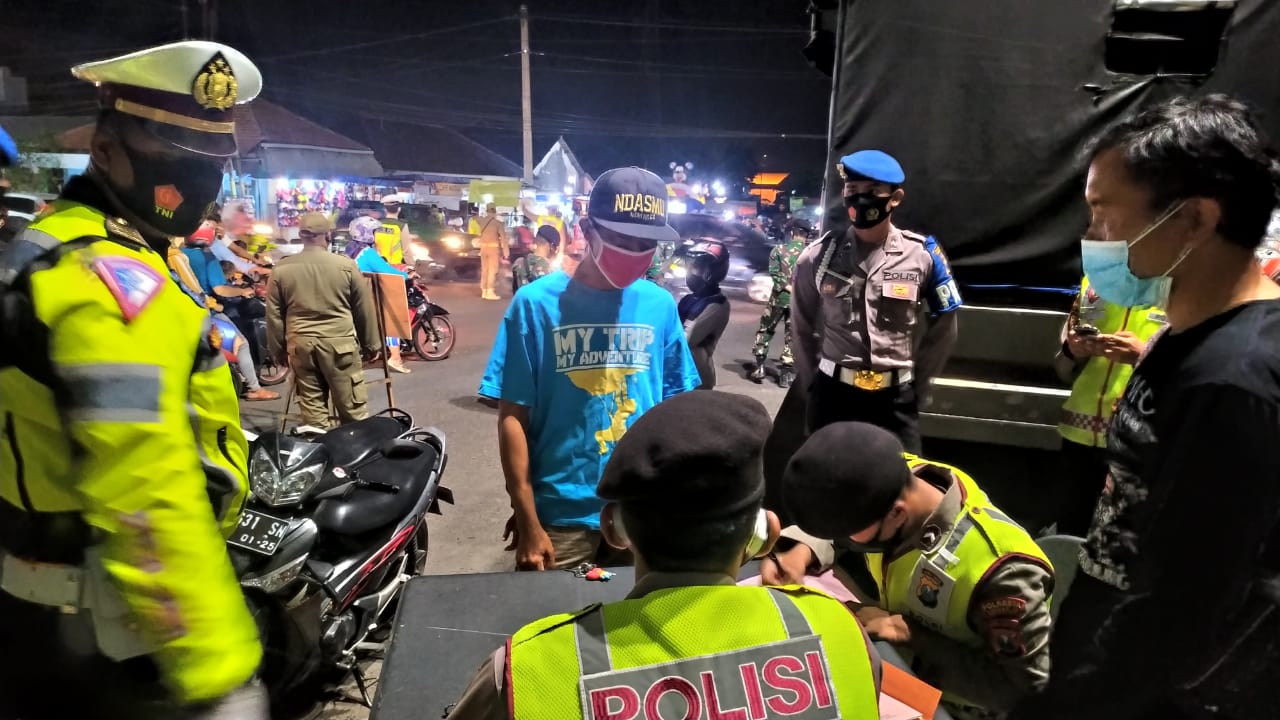 Petugas yang melakukan operasi yustisi di Sidoarjo, Sabyu (26/9), mendata warga yang tidak mematuhi aturan protokol kesehatan.