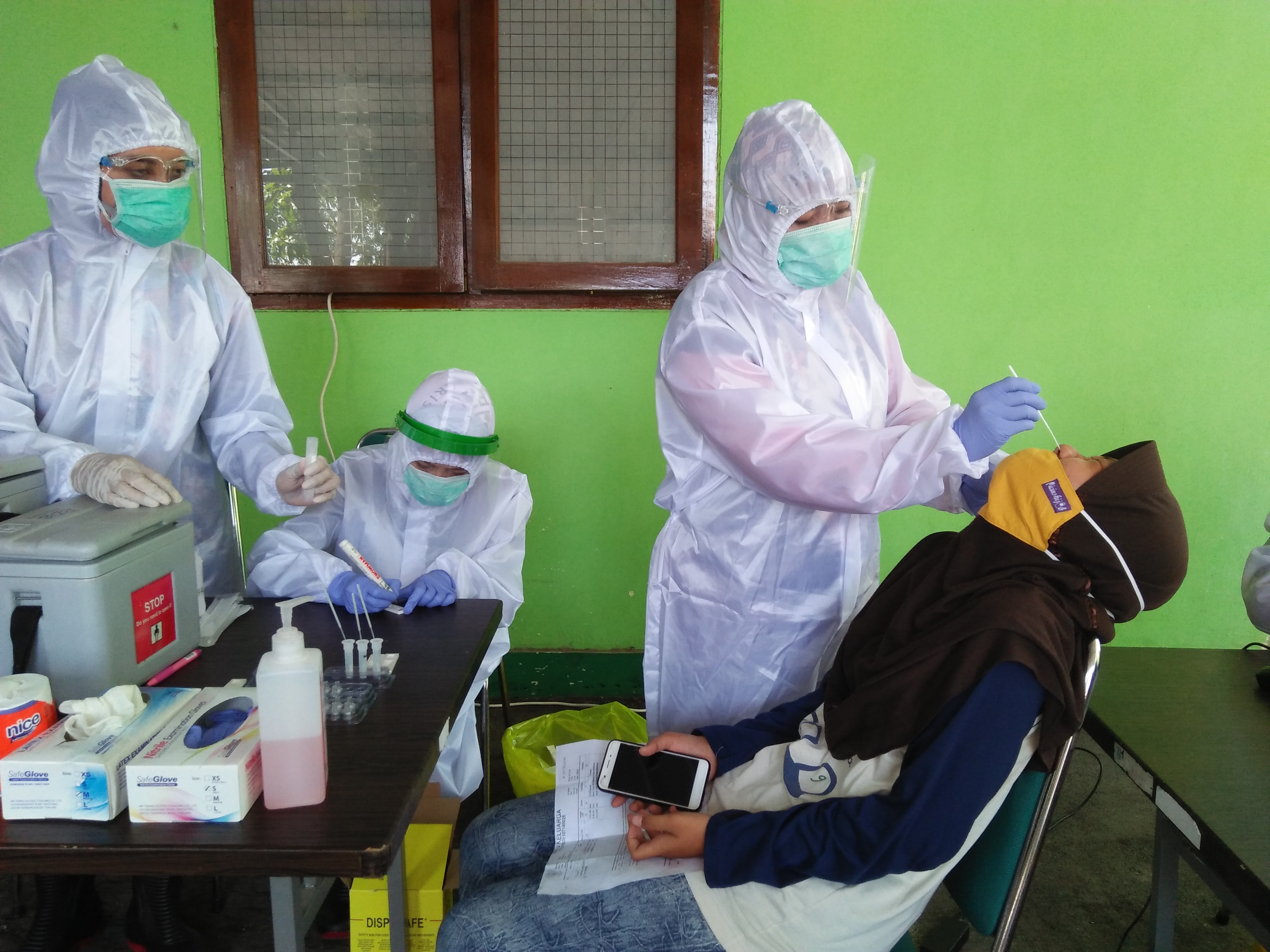 Petugas kesehatan melakukan tes swab kepada warga yang ikut nonton dangdut di lapangan Kota Tegal