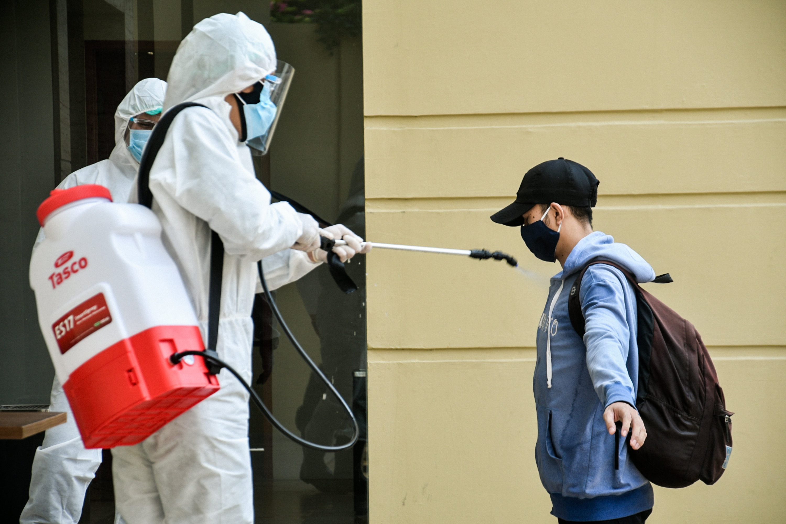 Petugas medis menyemprotkan disinfektan ke pasien Covid-19 berstatus OTG yang akan jalani isolasi mandiri di hotel