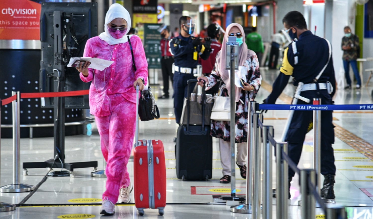 Penumpang berjalan menuju kereta setelah pemeriksaan kelengkapan berkas calon penumpang oleh petugas di Stasiun Gambir