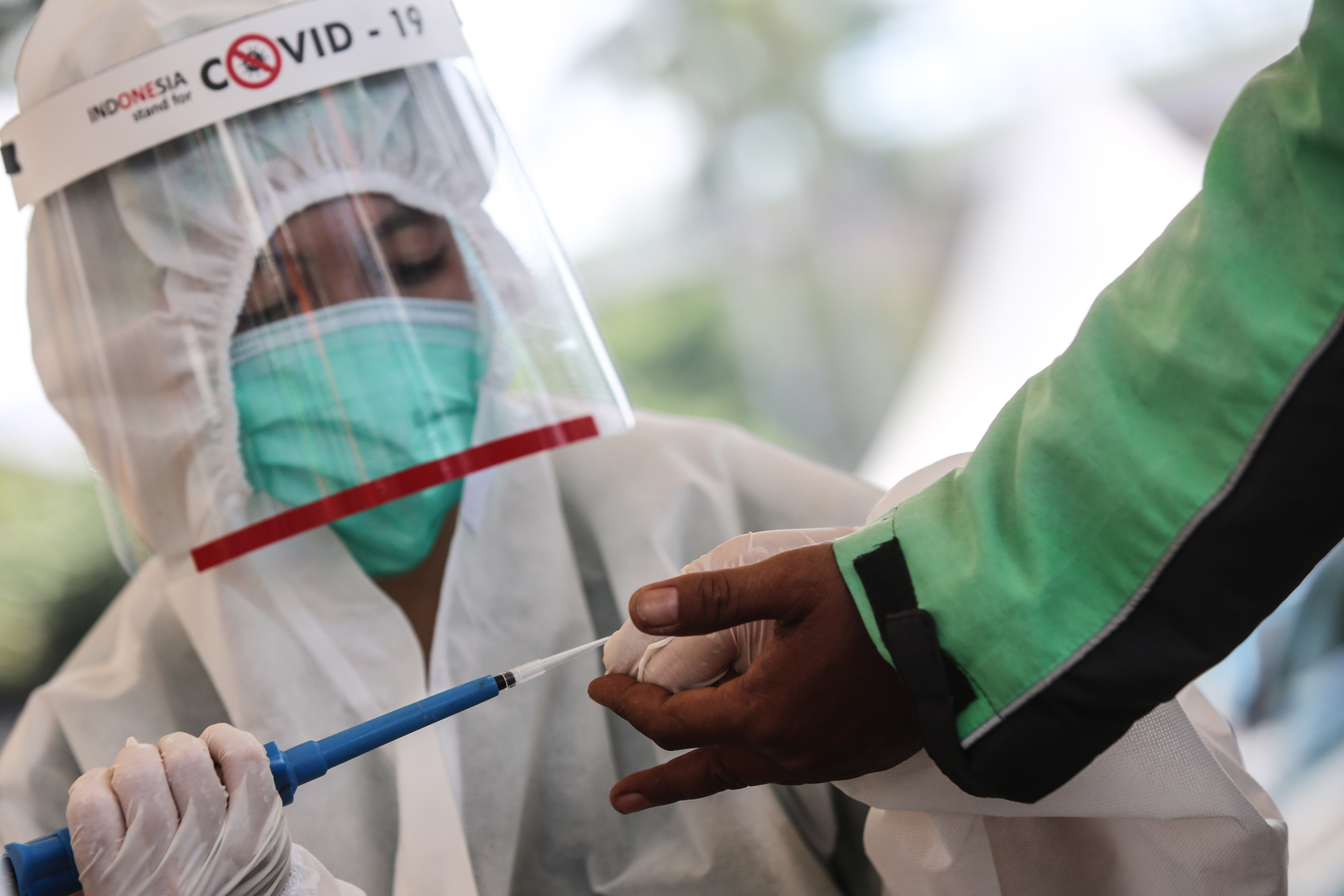 Petugas melakukan rapid test kepada masyarakat di depan gedung Kejaksaan Agung, Jakarta.