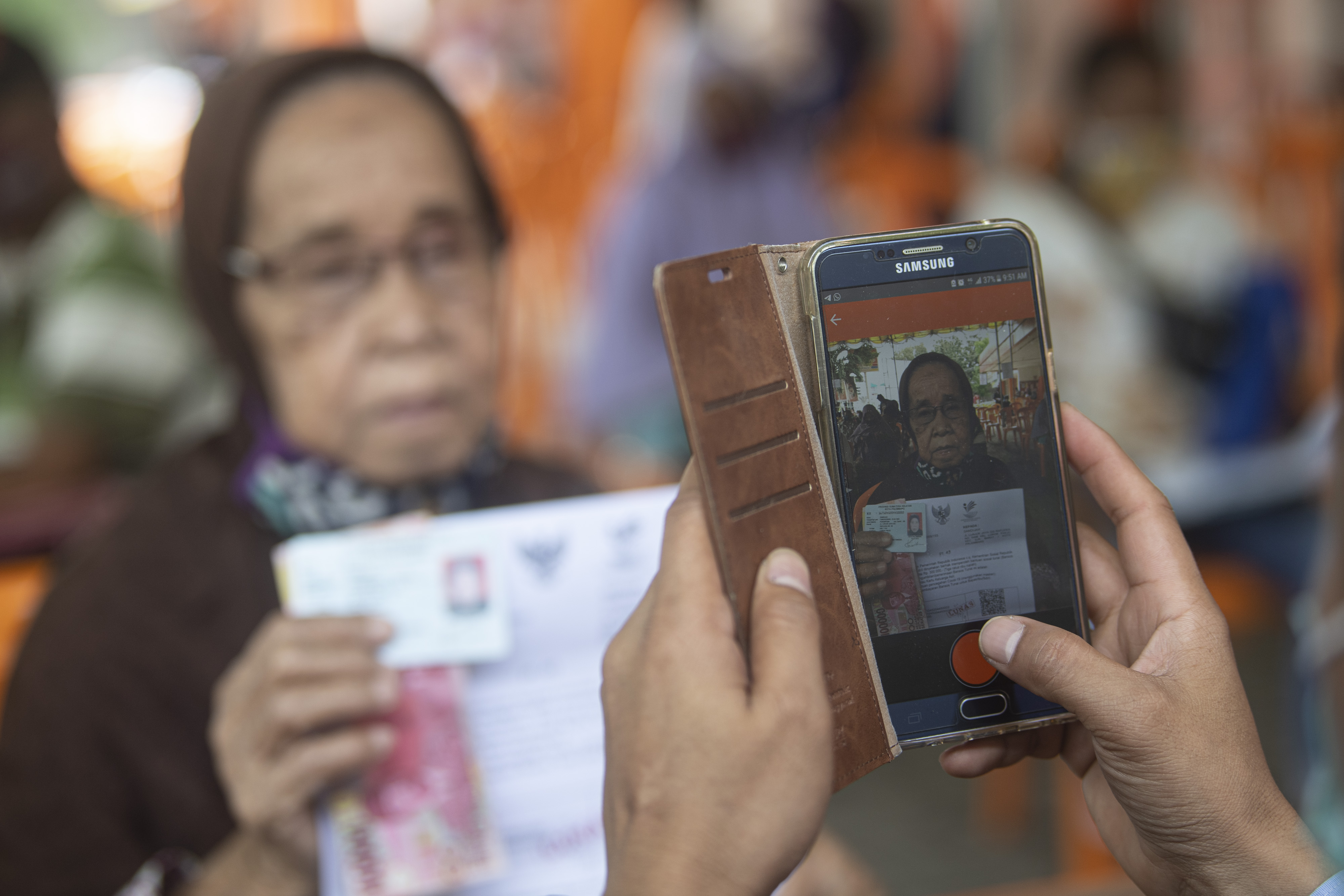 Petugas memotret penerima bantuan sosial tunai (BST) tahap enam di Kantor Pos Besar Merdeka Palembang, Sumatra Selatan, kemarin.