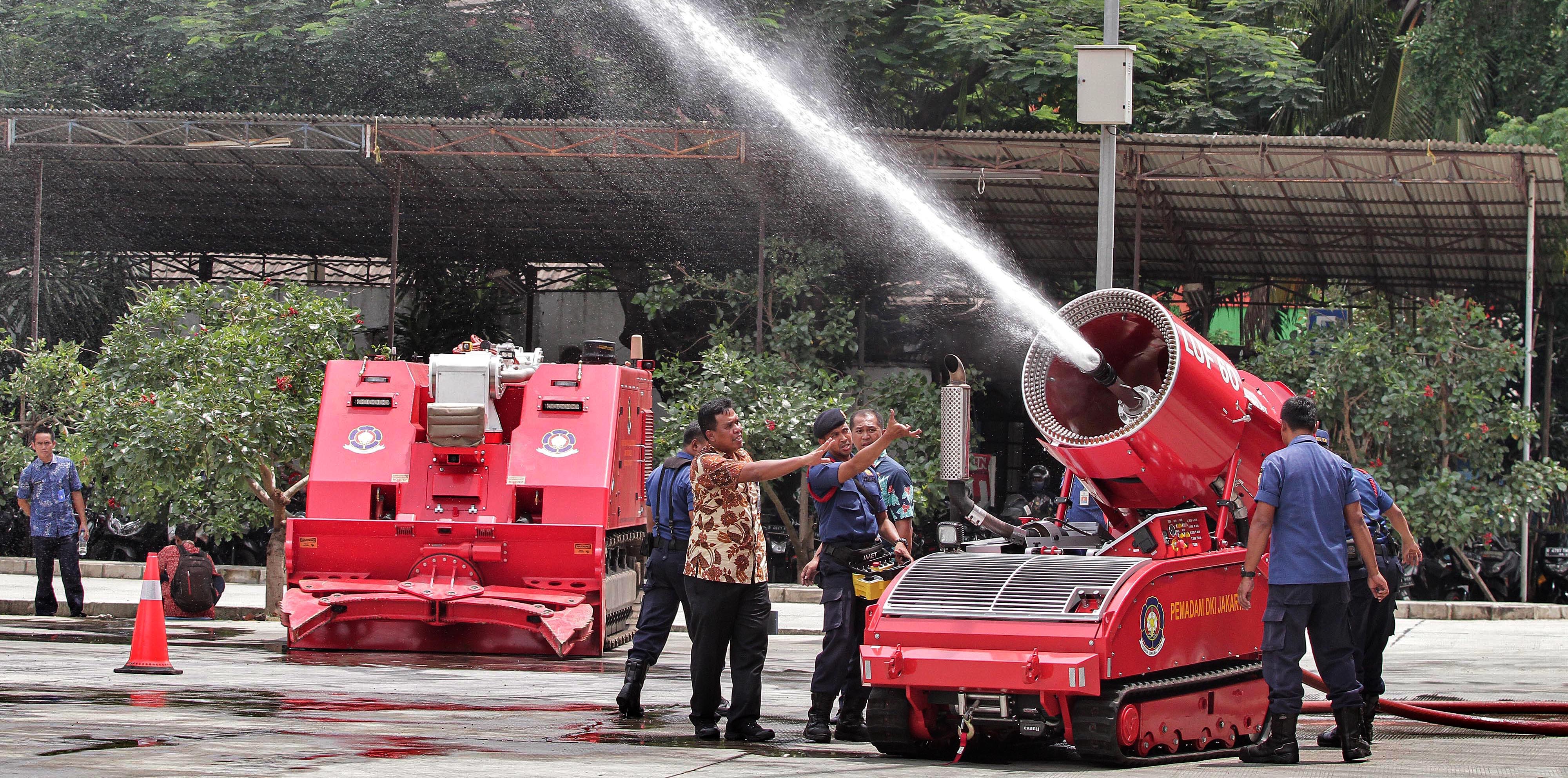  Petugas beraktivitas di dekat robot damkar LUF 60