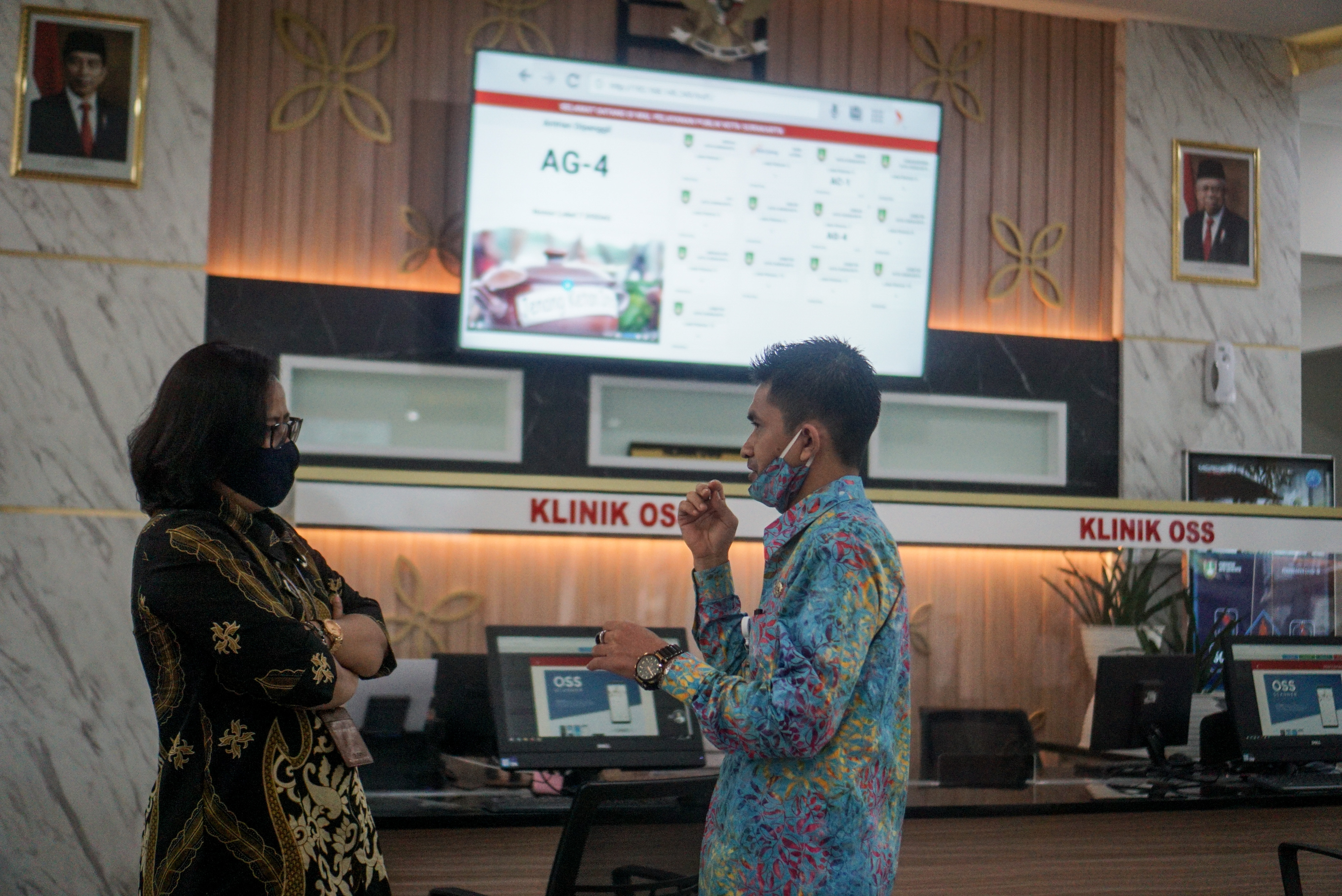 Petugas berbincang dengan warga yang mengantre layanan di Mal Pelayanan Publik, Solo, Jawa Tengah, Jumat (28/8)