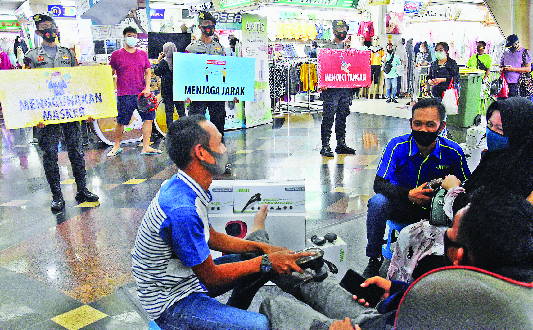 Polisi membentangkan poster imbauan saat menggelar kampanye penegakan protokol kesehatan