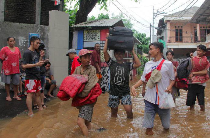 Warga menyelamatkan barang berharga di rumah yang terendam banjir di kawasan Cililitan, Kramat Jati, Jakarta Timur, awal tahun 2020.