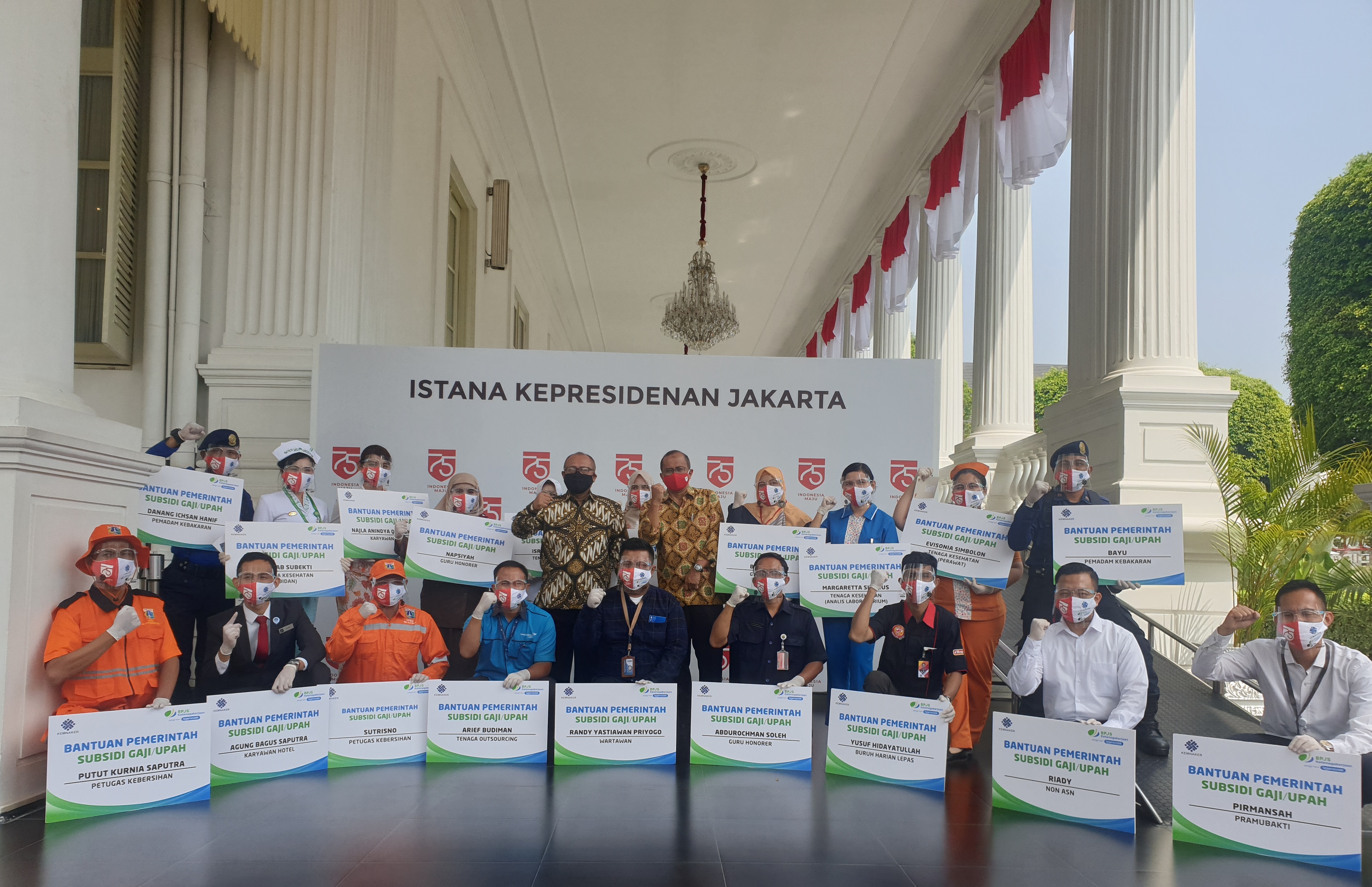 Para pekerja penerima Bantuan Subsidi Upah (BSU) berpose bersama setelah menerima BSU yang diserahkan Presiden Jokowi di Istana Negara.  