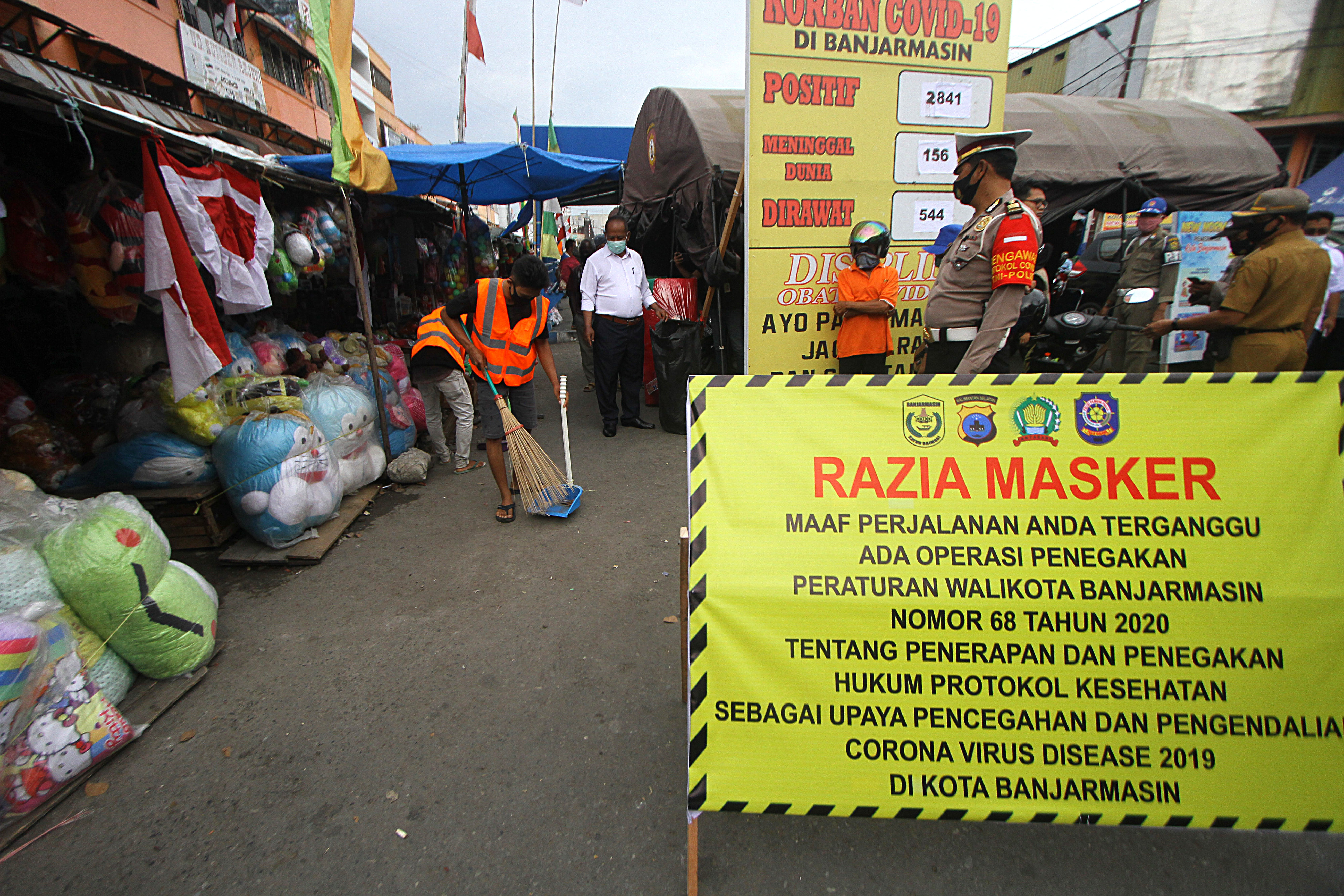 Pelanggar protokol kesehatan mendapatkan sanksi sosial menyapu jalan di kawasan Pasar Lima Banjarmasin, Kalimantan Selatan, Selasa (1/9). 