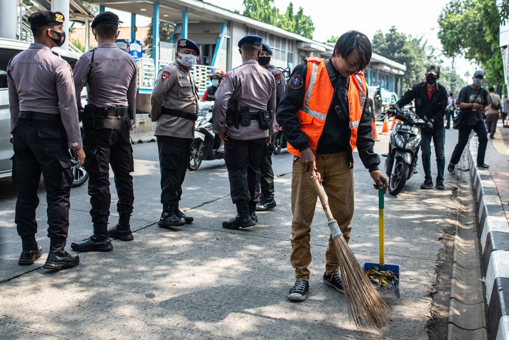  Warga yang melanggar protokol kesehatan menyapu bahu jalan saat terjaring Operasi Yustisi Protokol COVID-19 di kawasan Jati Padang, Jakarta