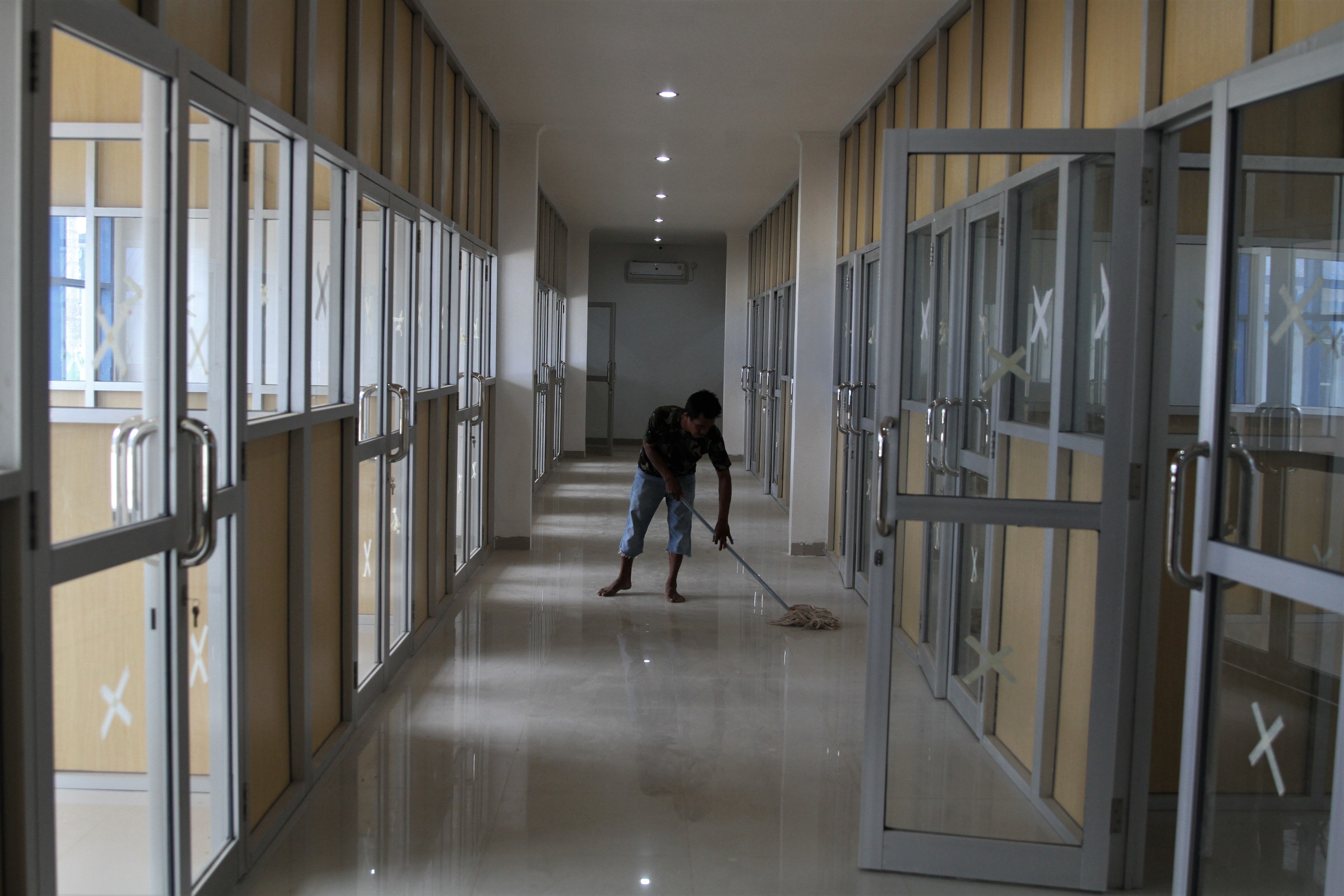 Pekerja membersihkan bekas ruang belajar SMA Negeri 1 Ranomeeto yang dijadikan rumah sakit sementara pasien covid-19, di Konawe Selatan.