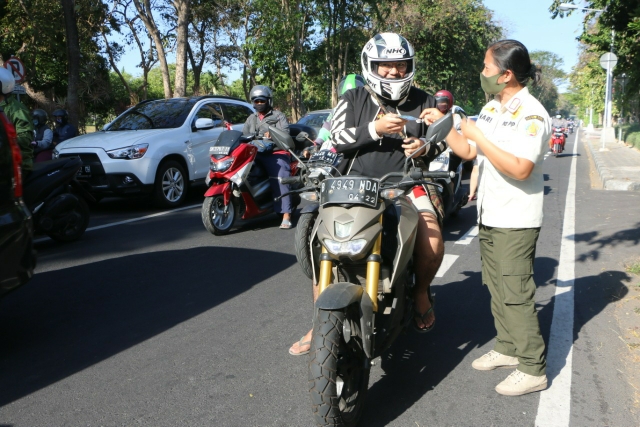 Petugas Satpol PP gencar sosialisasi pemakaian masker bagi warga melintas di jalan protokol Kota Denpasar, Bali, Jumat (30/8/2020).