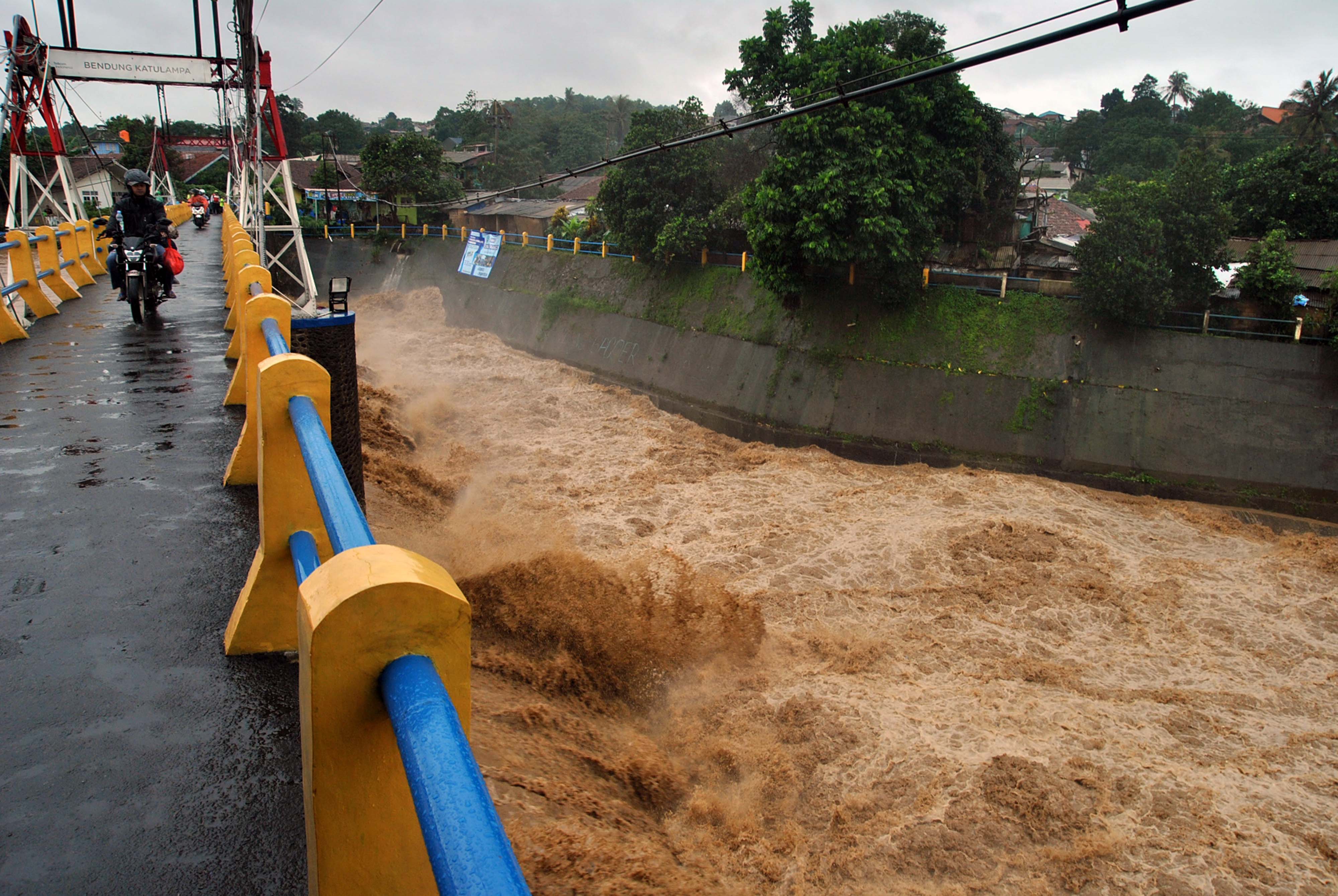 Pengendara motor melintas di atas jembatan Bendung Katulampa, Jawa Barat.