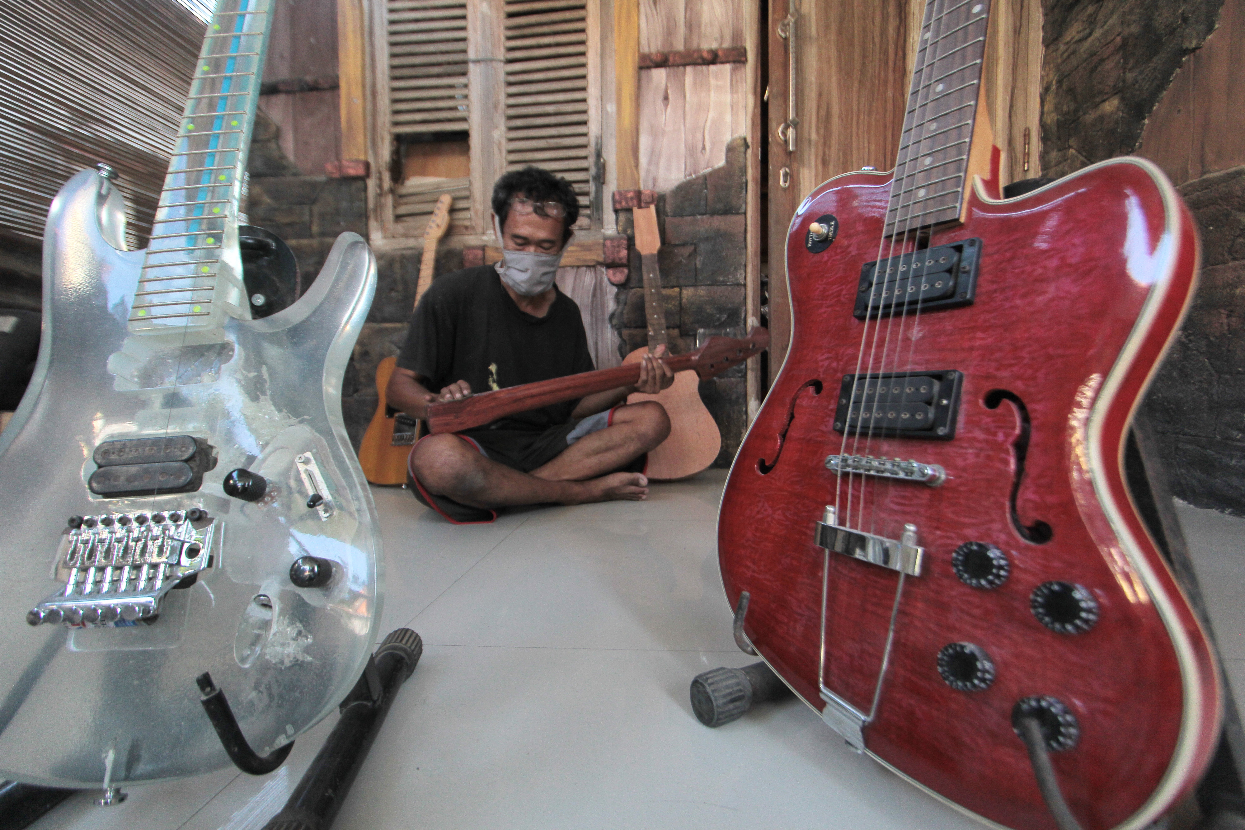 Perajin tengah menyelesaikan pesanan gitar elektrik di Indramayu, Jawa Barat.