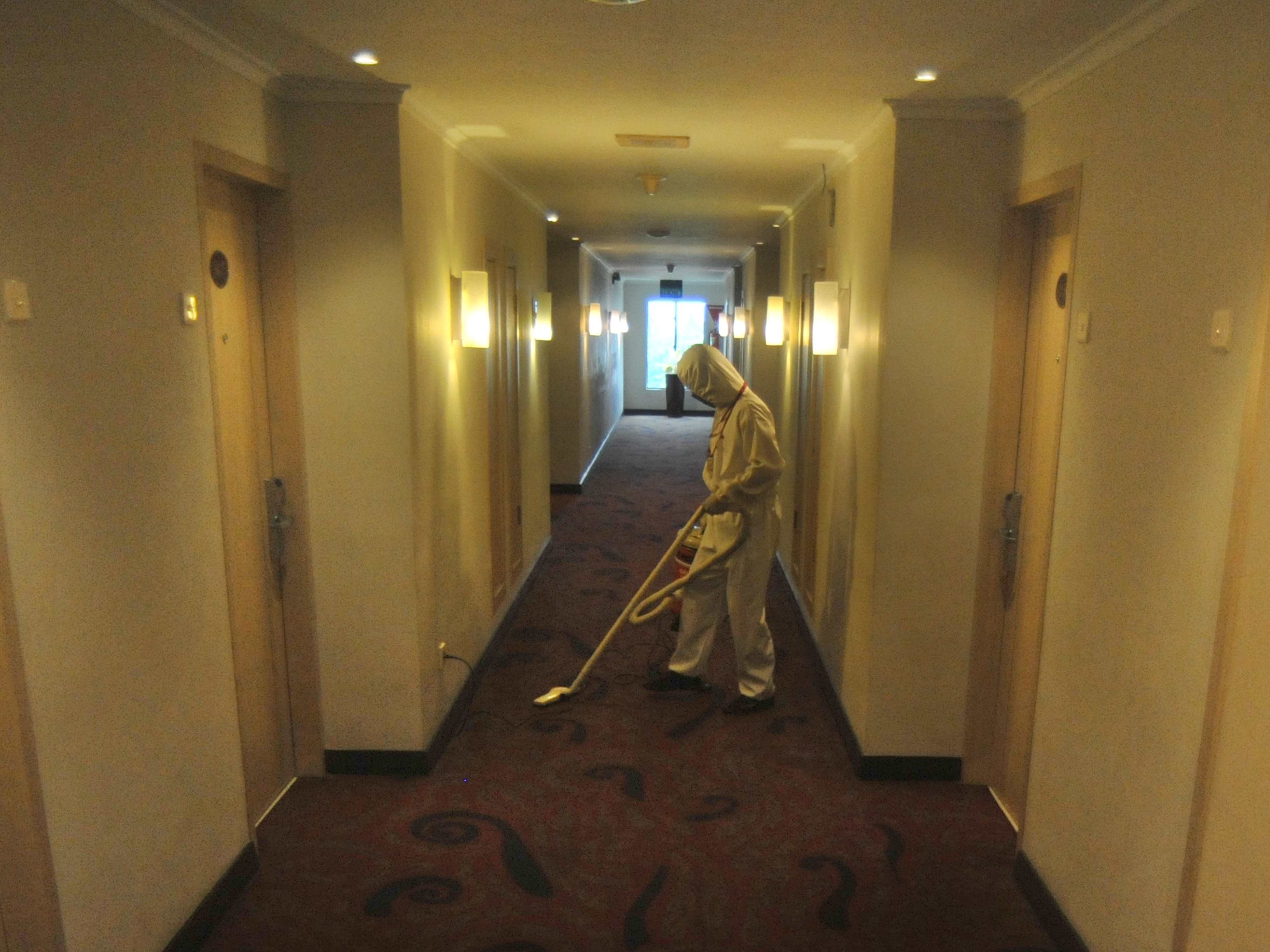 Petugas layanan kamar menggunakan pakaian APD lengkap saat membersihkan koridor di Hotel Pangeran Beach, Padang, Jumat (25/9).