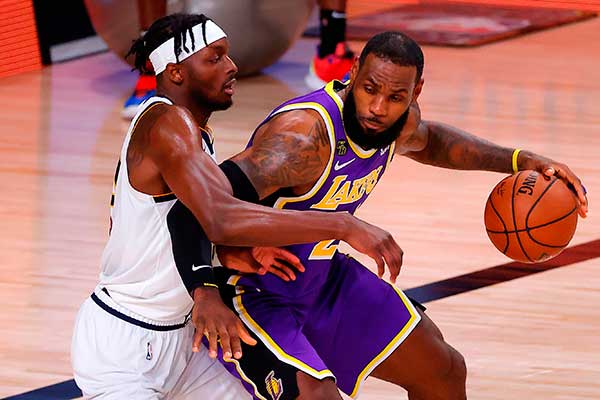 Pebasket LA Lakers LeBron James (kanan)  mendrible bola dan berusaha dihalangi oleh pemain Denver Nuggets Jerami Grant