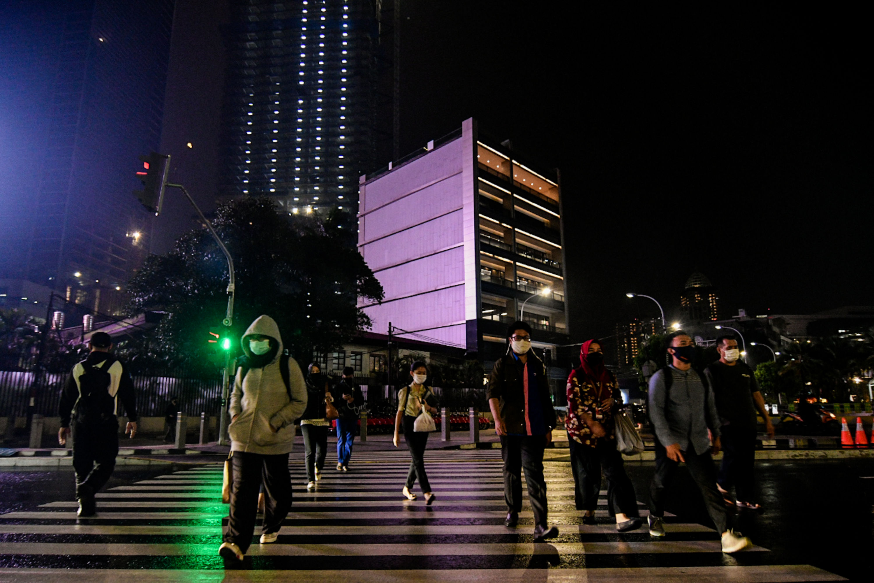Pekerja menyebrangi pelican crossing di kawasan Sudirman, Jakarta, Selasa (15/9).