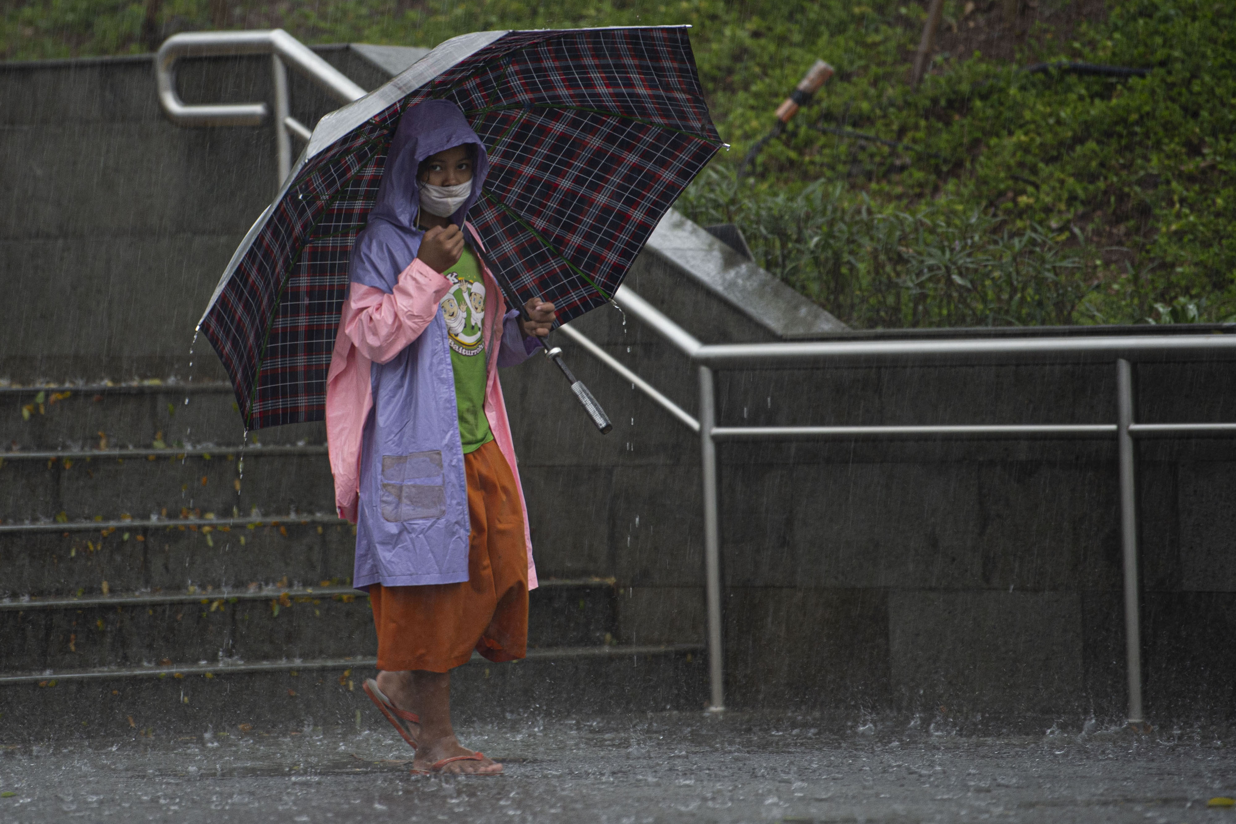  Warga menggunakan payung saat hujan mengguyur Stasiun MRT Dukuh Atas BNI, Jakarta.