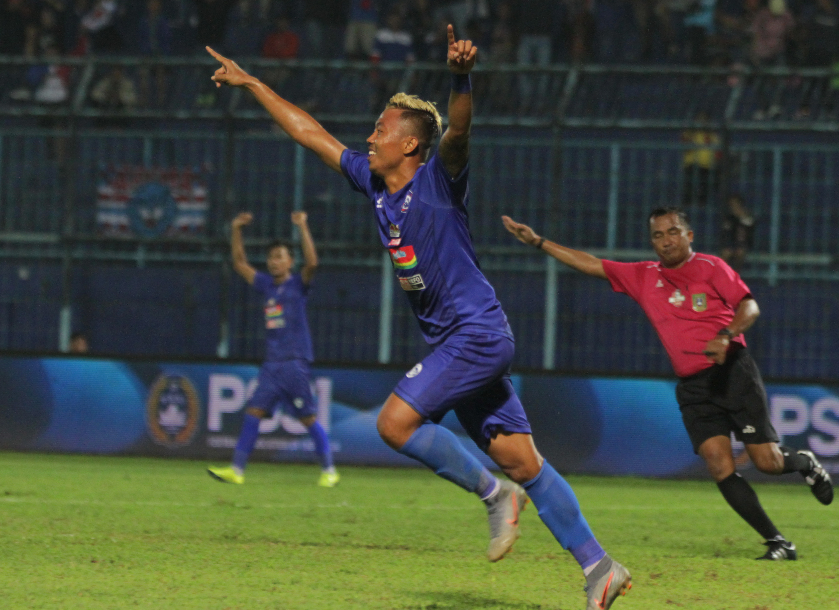Pesepakbola Arema FC, Yodo (tengah) melakukan selebrasi gol disaksikan wasit Tabrani (kanan) dalam pertandingan Piala Gubernur Jatim Grup B