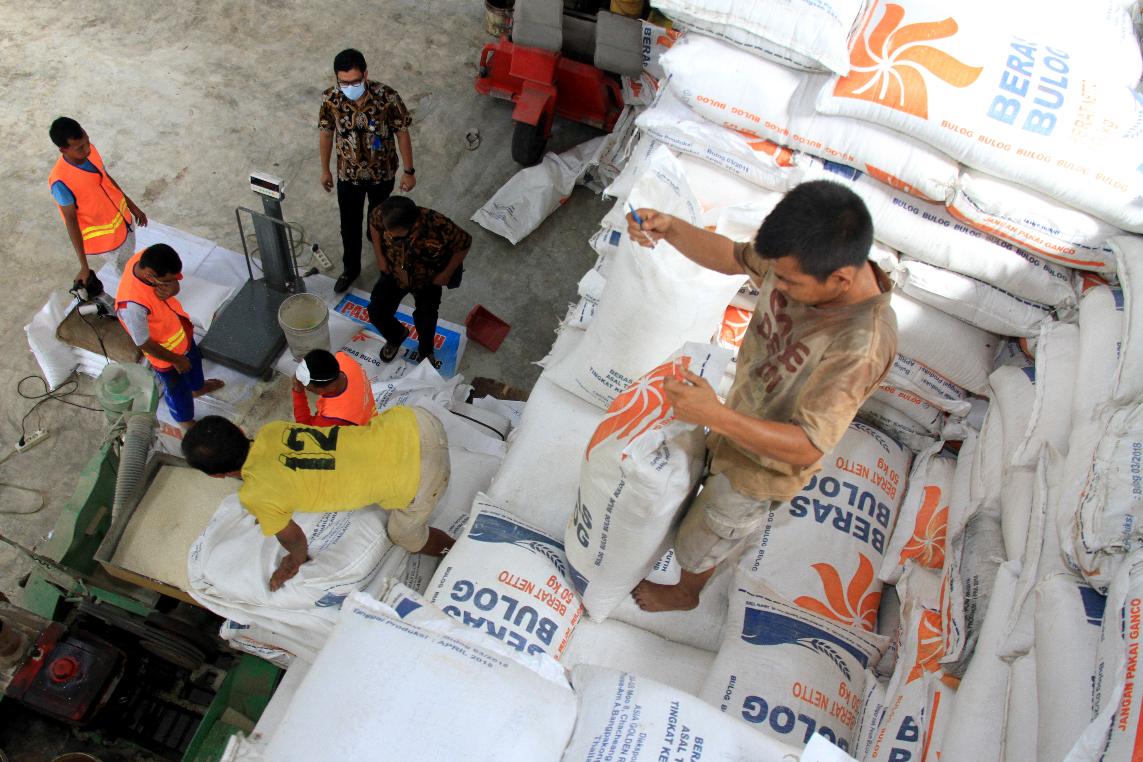 Sejumlah pekerja mengemas beras untuk Bantuan Sosial Beras (BSB) di gudang Perum Bulog Cabang Meulaboh, Aceh Barat, Aceh.