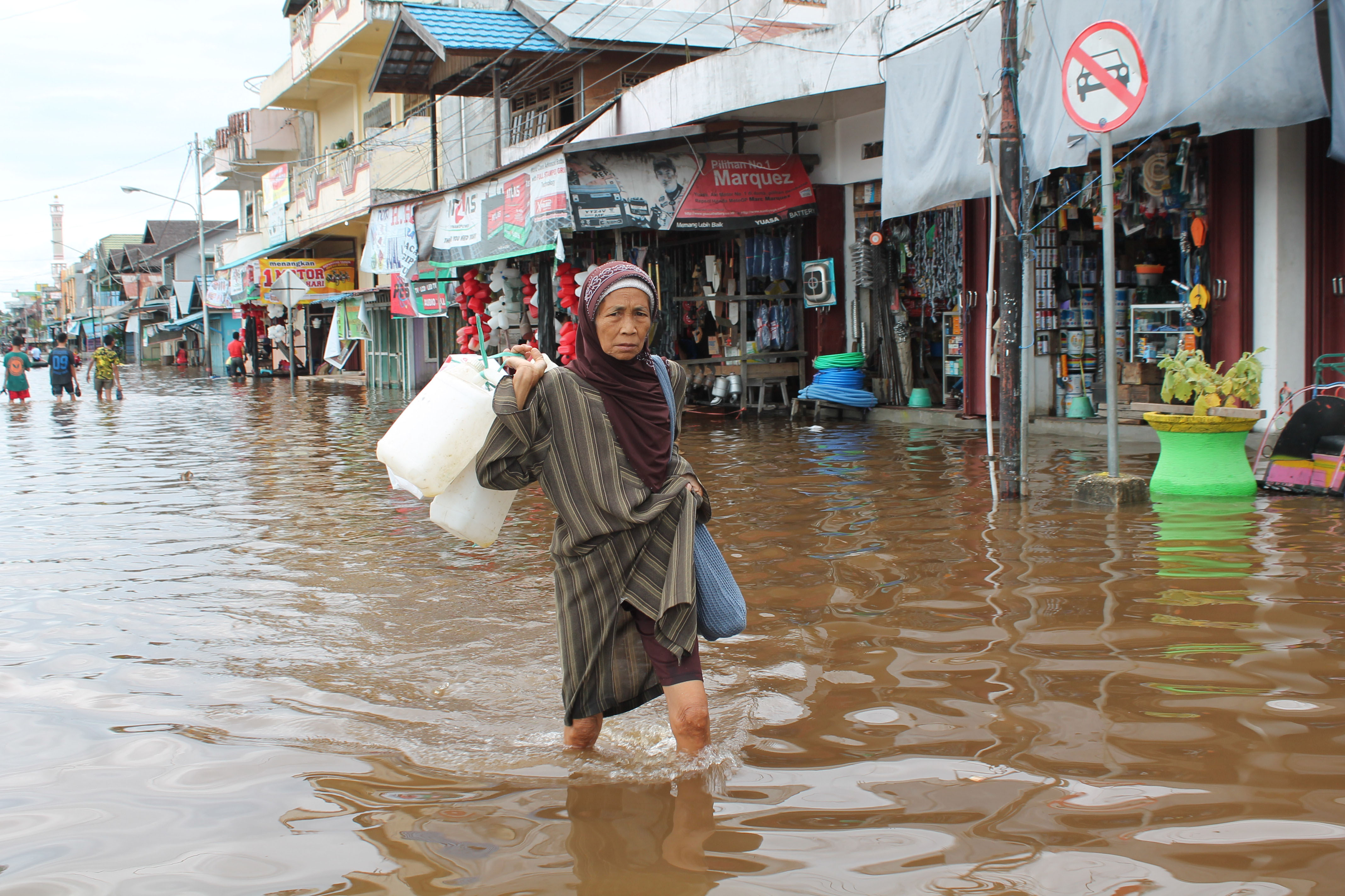 Seorang warga melintasi kawasan perdagangan di Jalan Panglima Batur Muara Teweh,  Barito Utara, Kalteng yang terendam banjir.