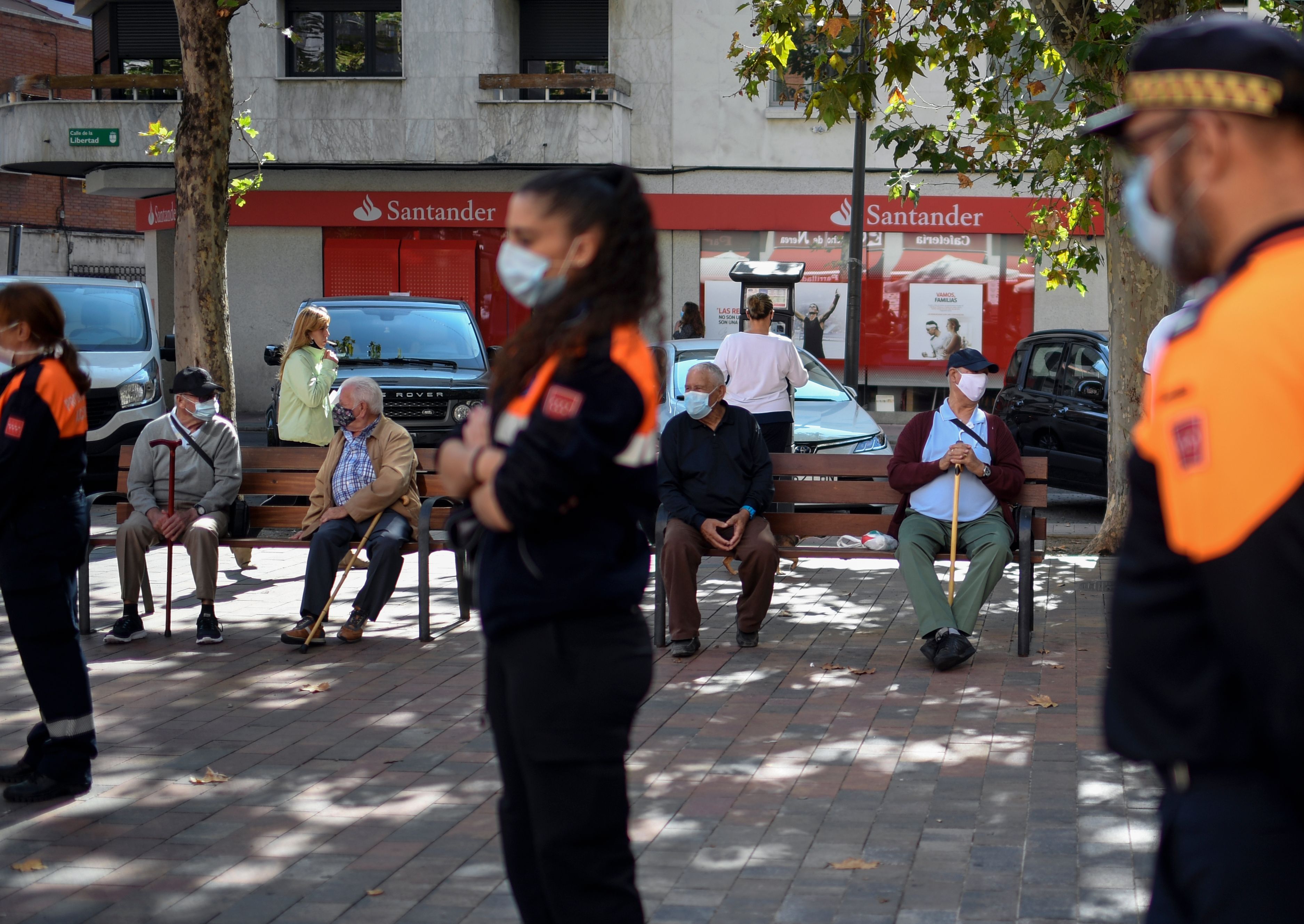 Warga bersantai menggunakan masker di kawasan Usera, Madrid, Spanyol.