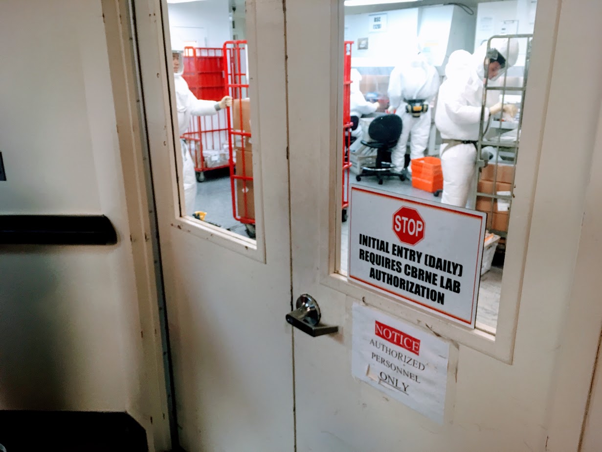 Personel Departemen Pertahanan AS mengenakan pakaian pelindung memeriksa surat-surat yang masuk di sebuah lokasi di dekat Pentagon.