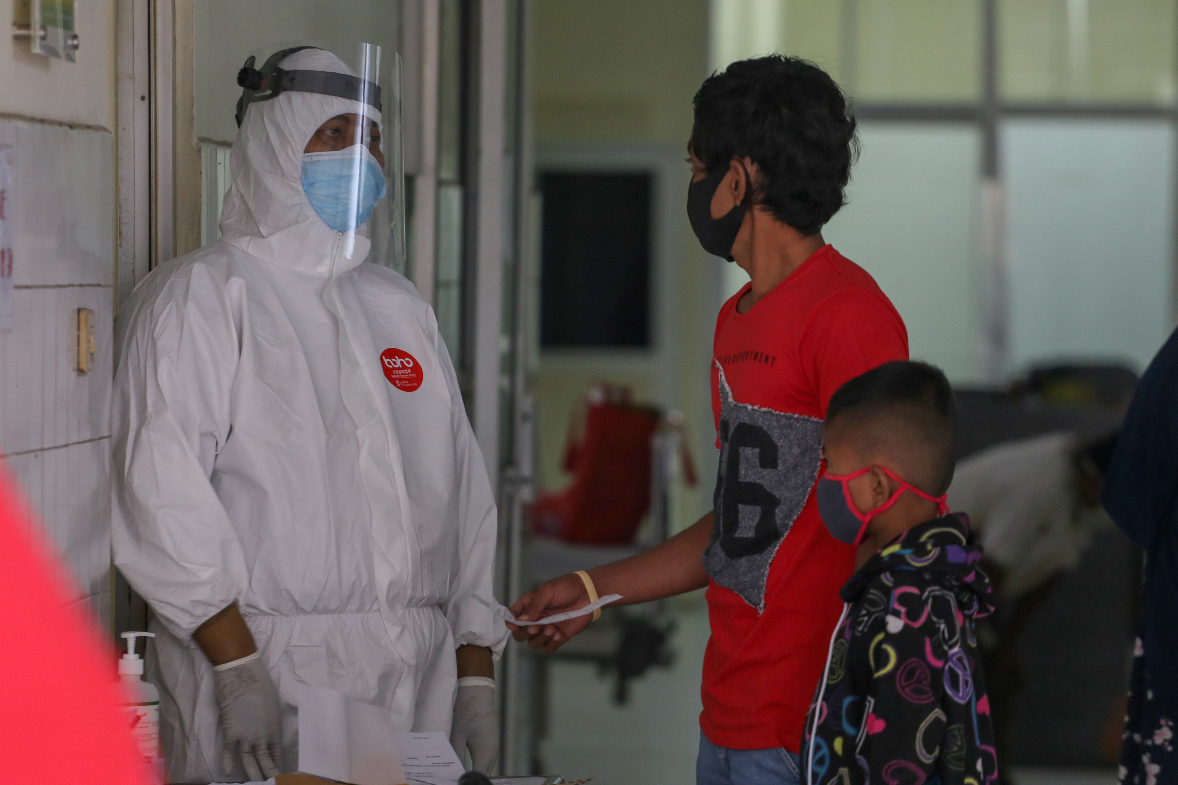 tenaga medis menggunakan APD berbincang dengan keluarga pasien