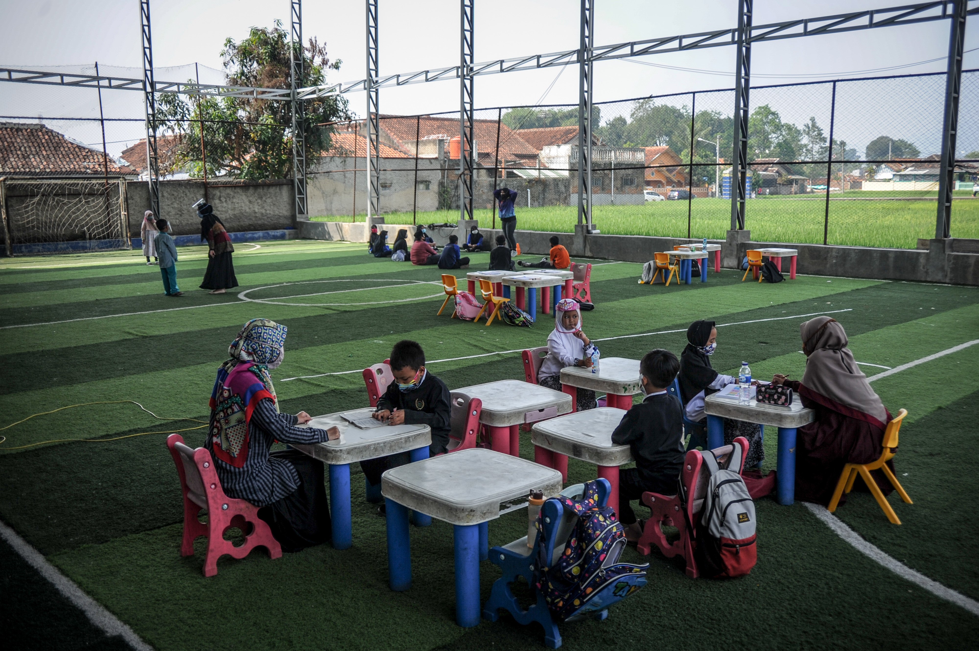 Siswa Ibtidaiyah mengikuti kegiatan belajar mengajar di lapangan futsal Sekolah Satu Atap Ibnu Aqil Ibnu Sina (IAIS) di Soreang
