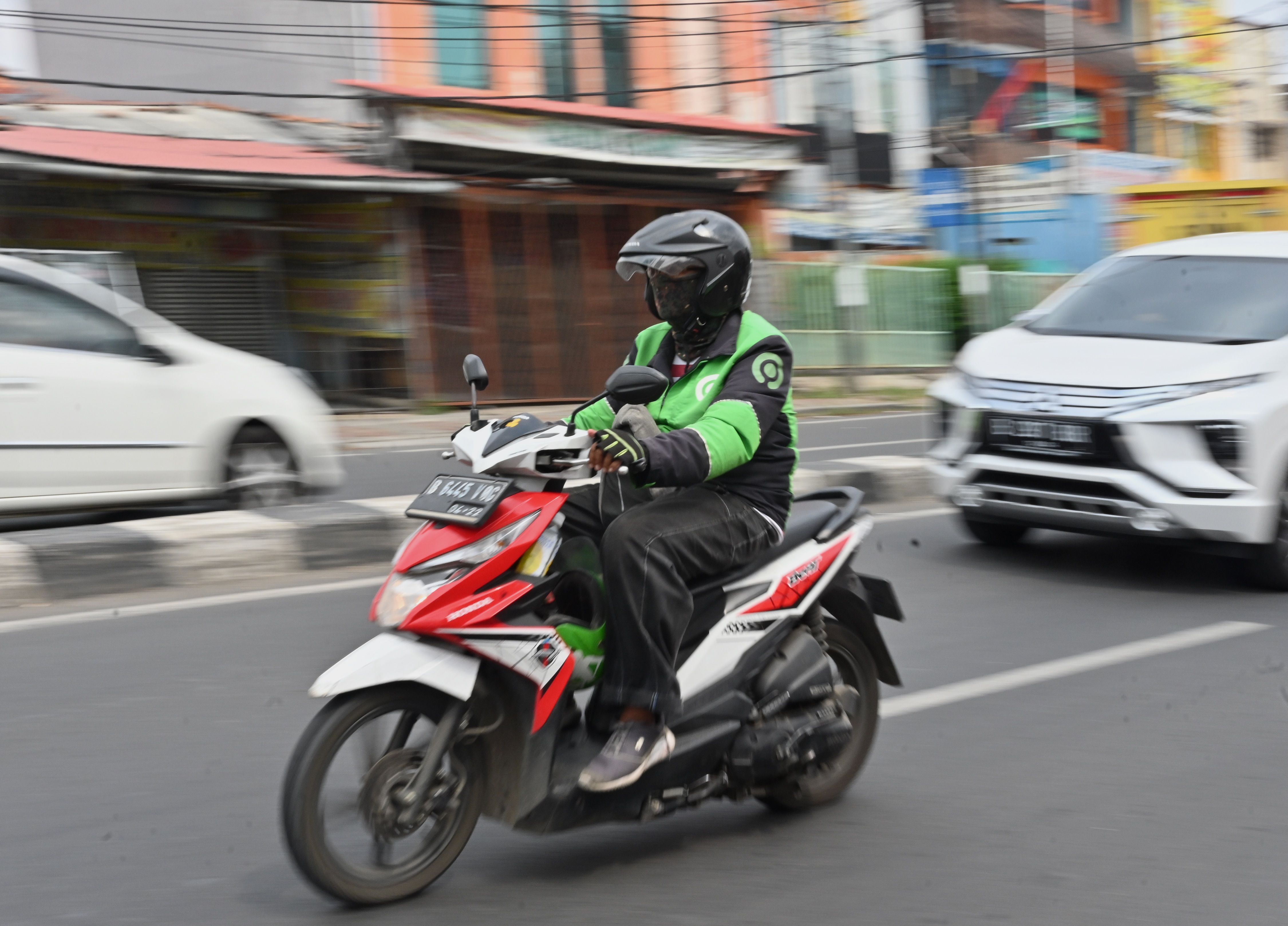 Pengemudi Gojek melintas di jalan Jakarta.