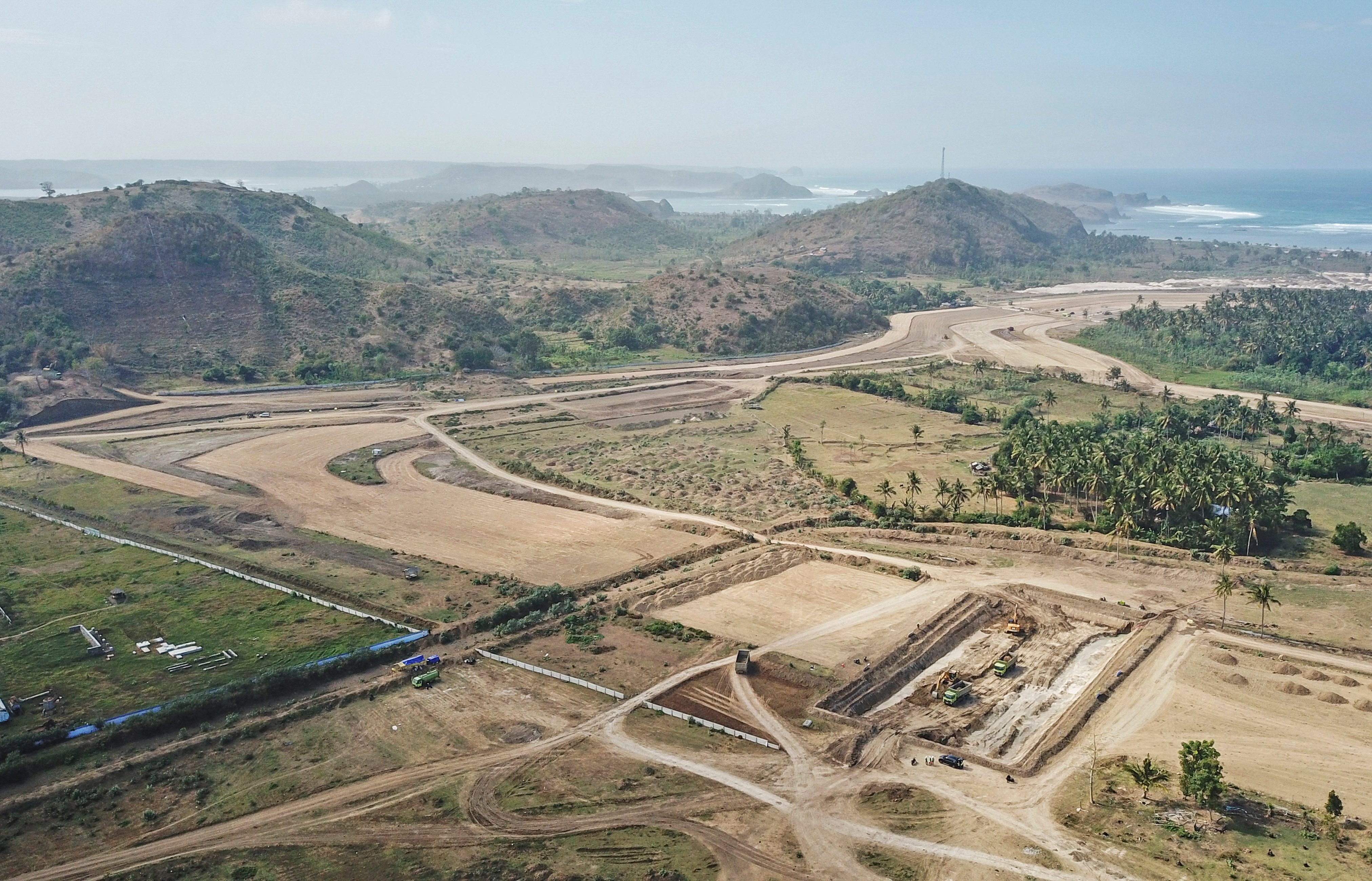 Foto udara operator menggunakan alat berat mengerjakan pembangunan 