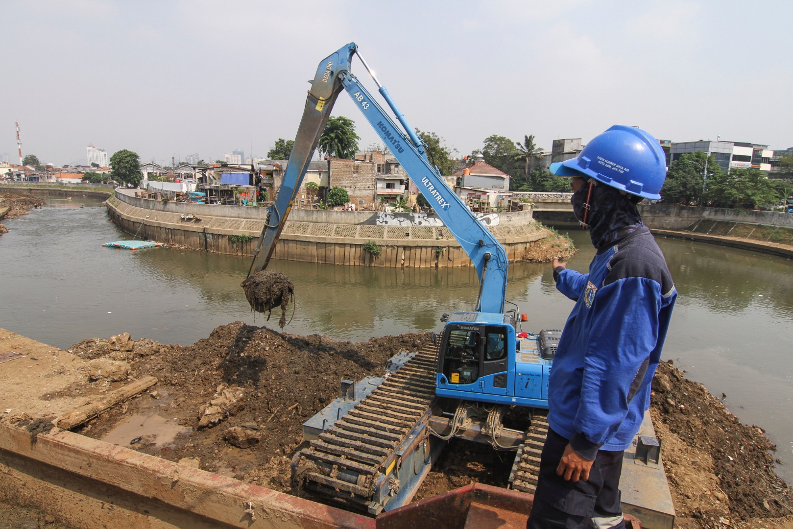  Petugas Dinas Sumber Daya Air DKI Jakarta melakukan pengerukan endapan lumpur di Kali Ciliwung, Kampung Melayu.