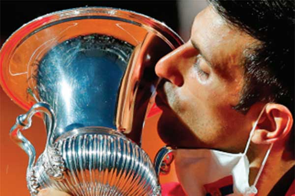 Petenis putra asal Serbia Novak Djokovic mencium trofi Italia Terbuka yang dimenanginya, kemarin