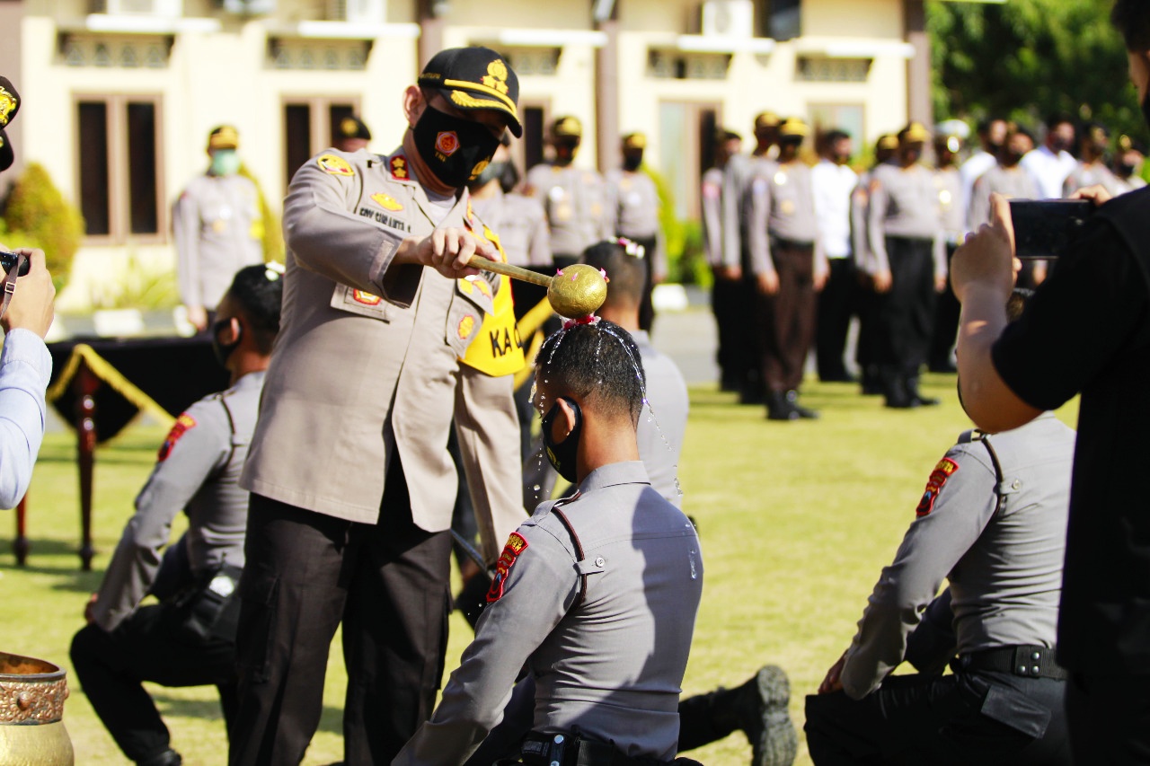 Kapolres AKB Edy Suranta Sitepu mengguyur kepala brigadir remaja dengan air kembang pada acara tradisi pembaretan di halaman Mapolres Klaten