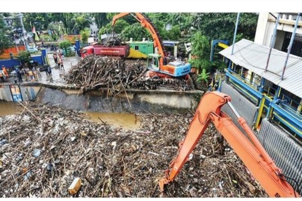 Petugas UPK Badan Air Dinas Lingkungan Hidup DKI Jakarta membersihkan sampah yang menumpuk di Pintu Air Manggarai, Jakarta, kemarin.