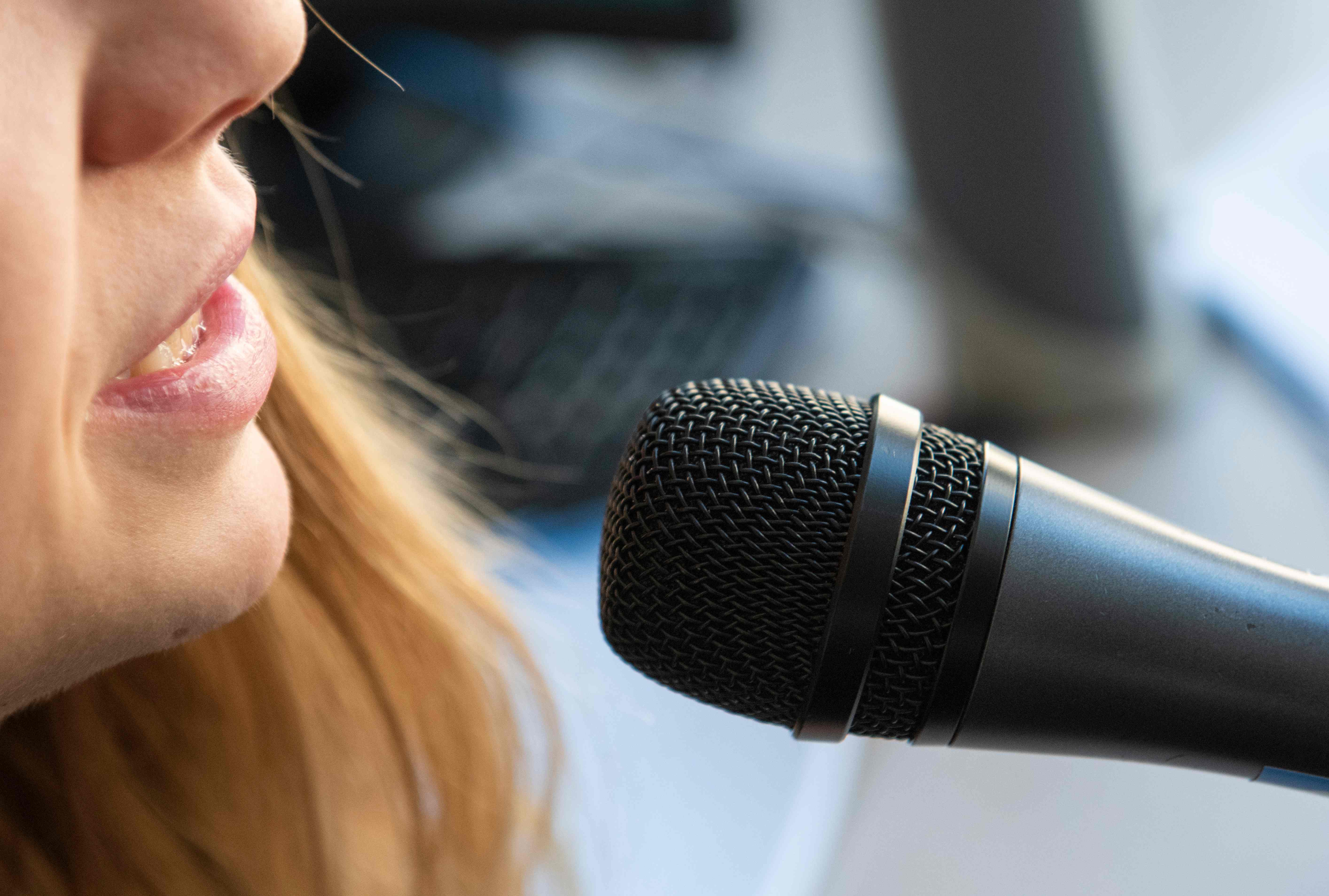 Seorang perempuan menyanyi di depan mikrofon bisa berisiko menyebarkan virus korona karena mengeluarkan suara keras. 