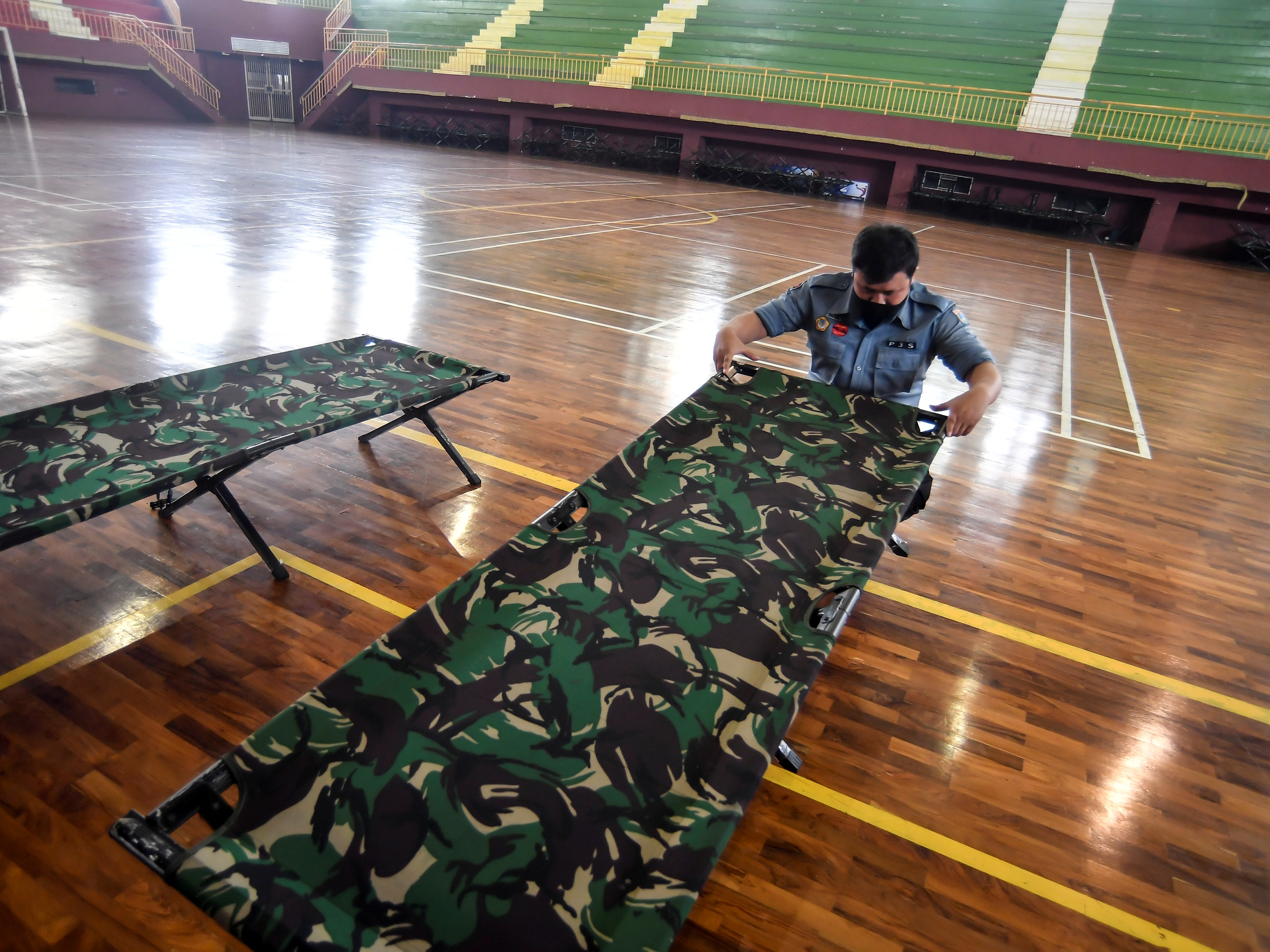 Petugas dinas sosial menyiapkan tempat tidur bagi warga yang terkena virus Covid-19 baik Orang Tanpa Gejala atau Dengan Gejala di GOR