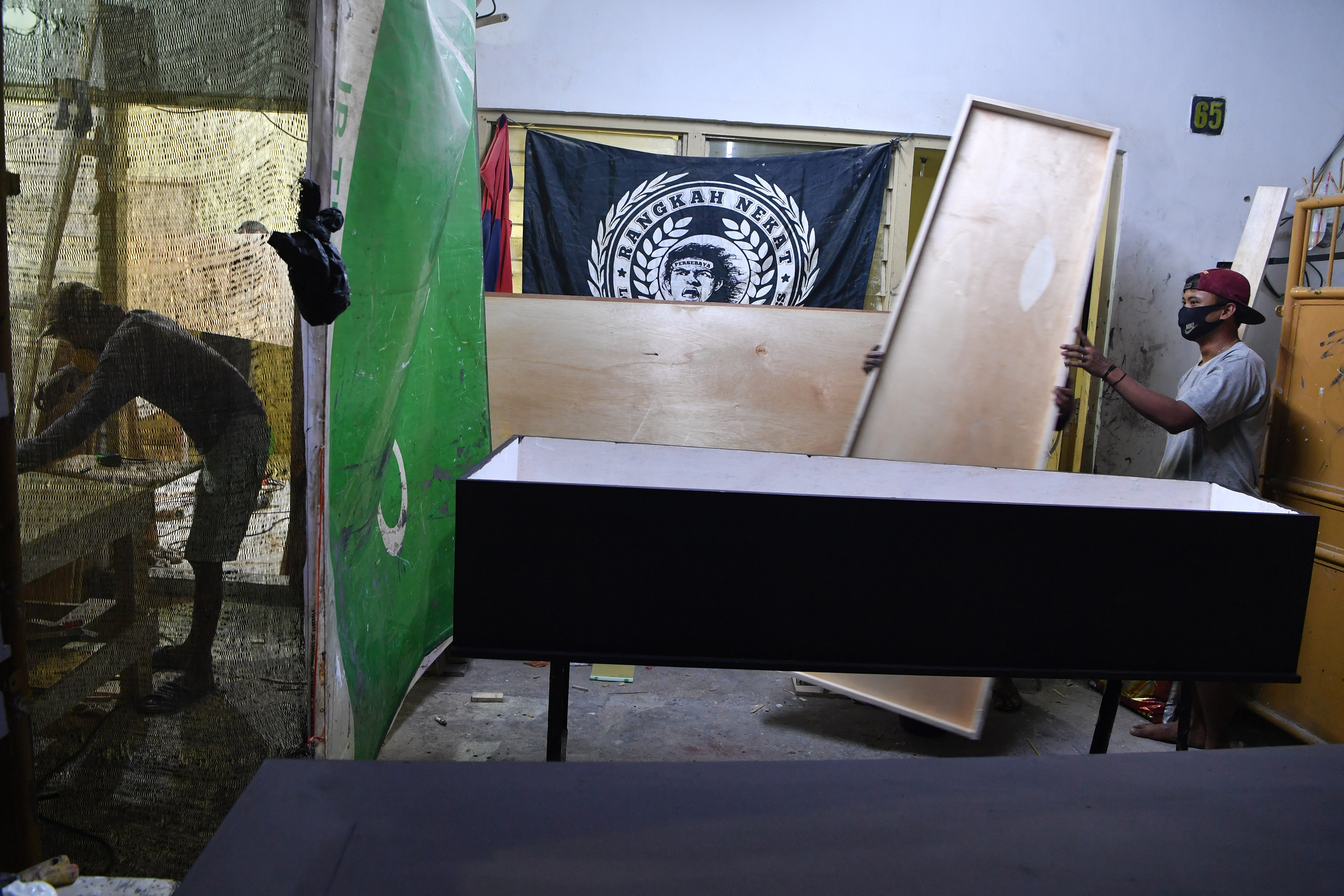 Pekerja menyelesaikan pembuatan peti jenazah COVID-19 di Surabaya, Jawa Timur, Kamis (30/7).