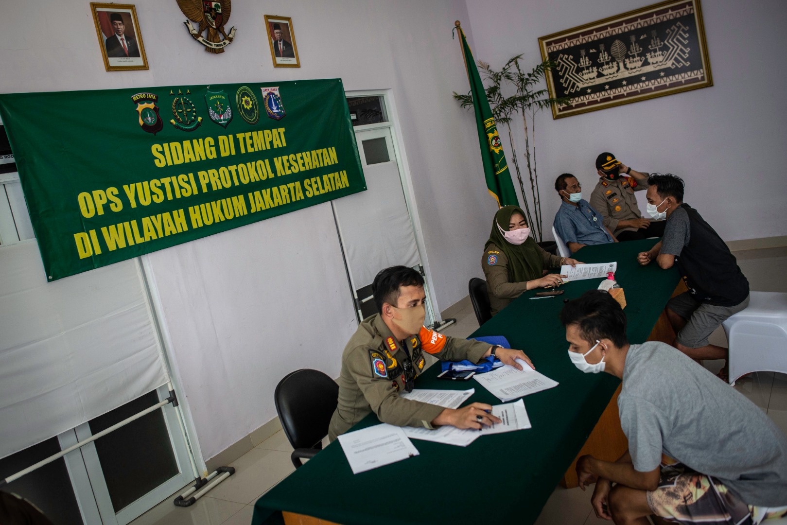 Anggota Satpol PP melakukan sidang di tempat pelanggar protokol kesehatan covid-19 di kawasan Jati Padang, Jakarta, Kamis (17/9).