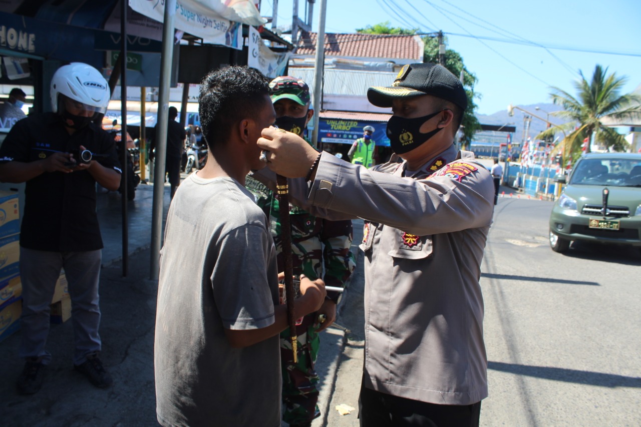 Polisi memberikan masker bagi warga yang tidak mengenakan