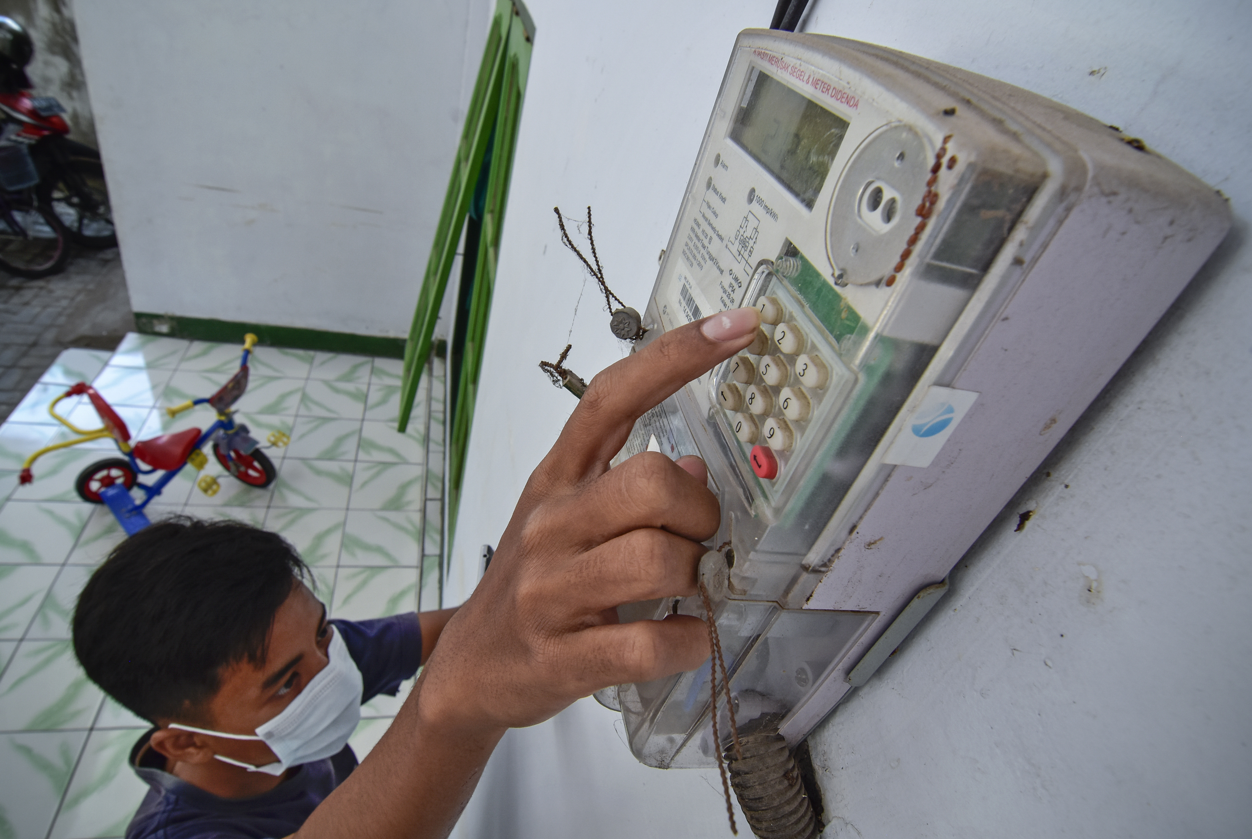 STIMULUS TARIF LISTRIK: Seorang laki-laki memasukkan pulsa token listrik di rumahnya di Ampenan, Mataram, NTB, Sabtu (15/8/2020)